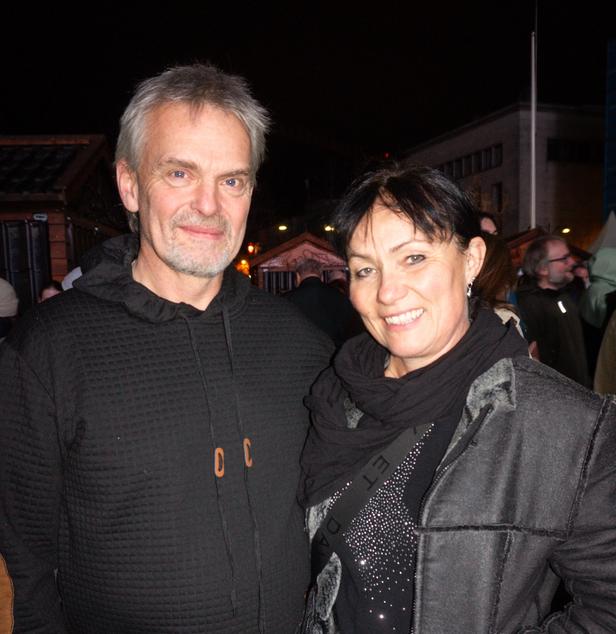An older couple, dressed in black, at a Christmas market
