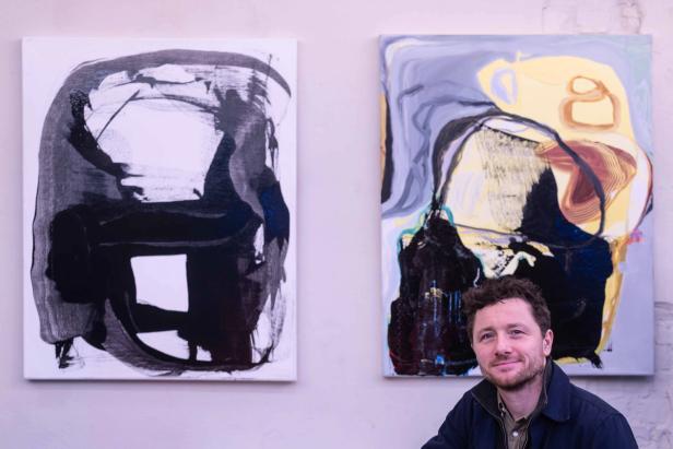 William in front of two paintings