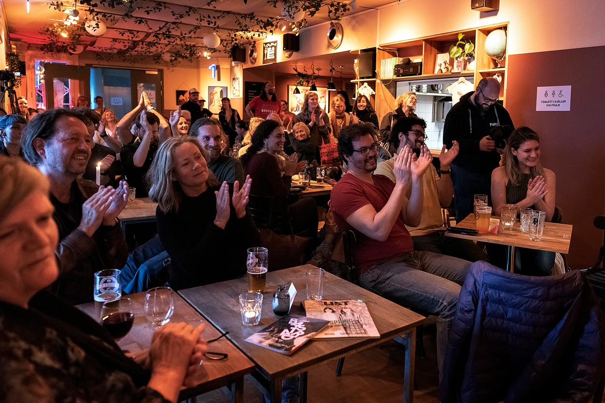 Audience at a cafe setting listening to a concert