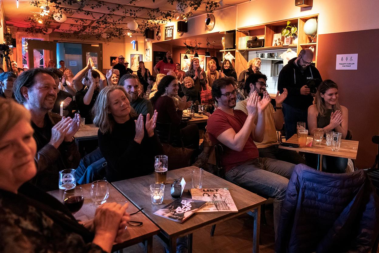 Audience at a cafe setting listening to a concert