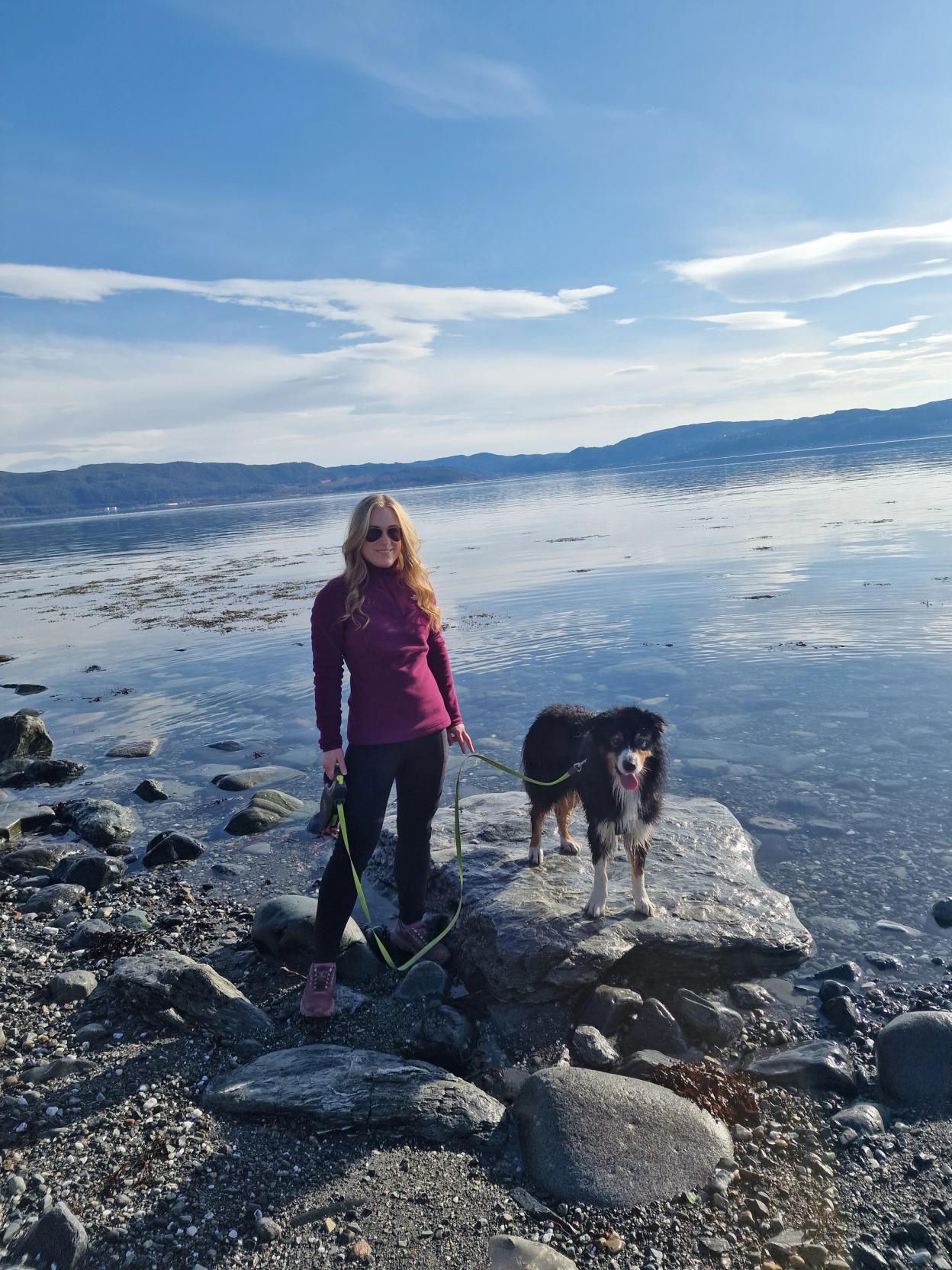 Simone and dog - Taco - on a rocky beach next to the fjord-