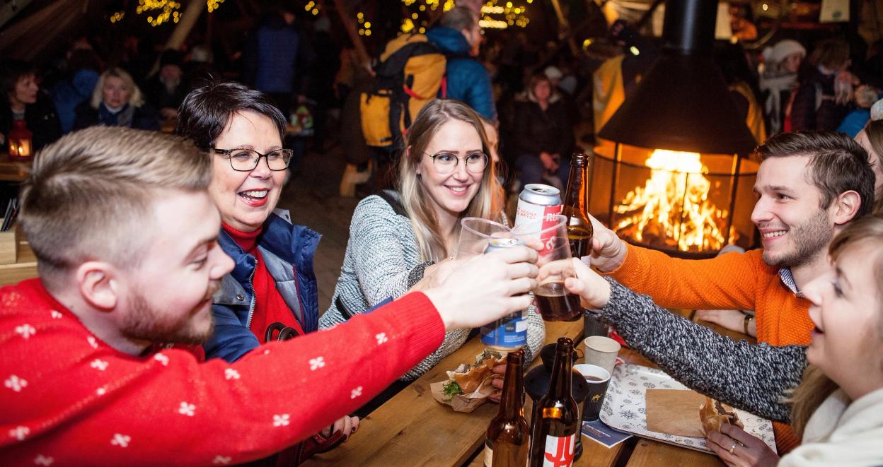 5 people toasting at makeshuft cafe table at Trondheim Christmas Market