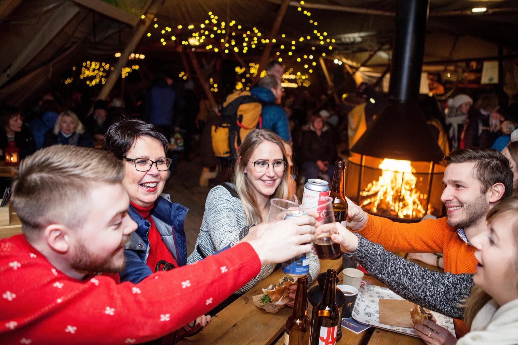 5 people toasting at makeshuft cafe table at Trondheim Christmas Market