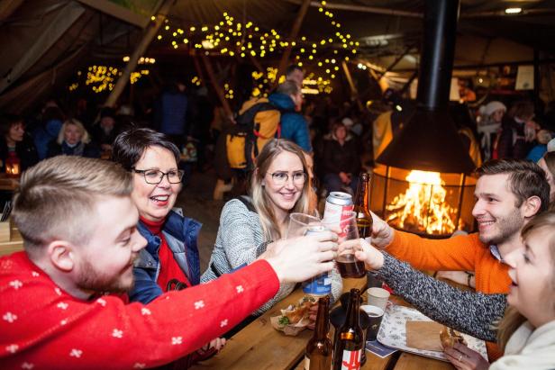 5 people toasting at makeshuft cafe table at Trondheim Christmas Market