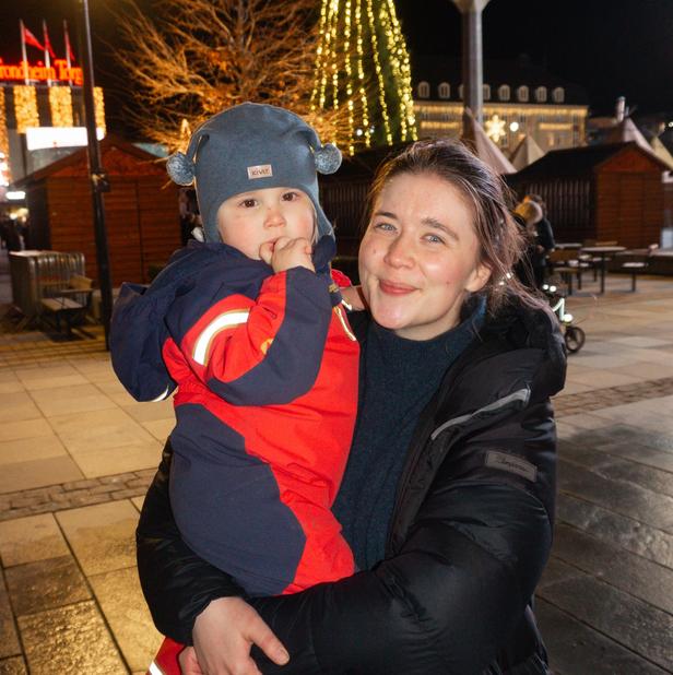 A woman holding her baby at a Christmas market