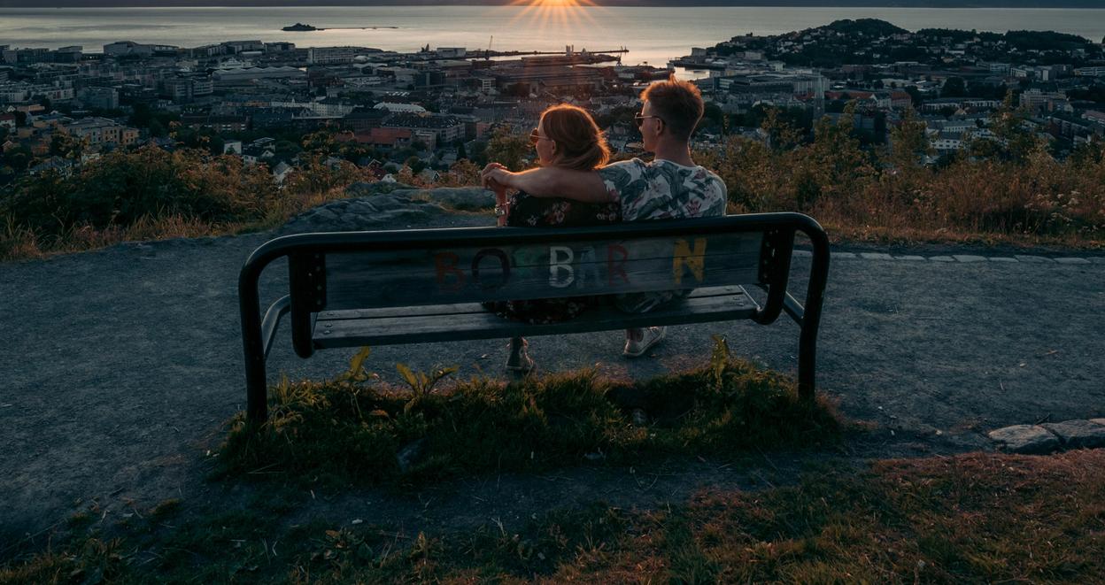 Two people sitting on a bench during sunset.
