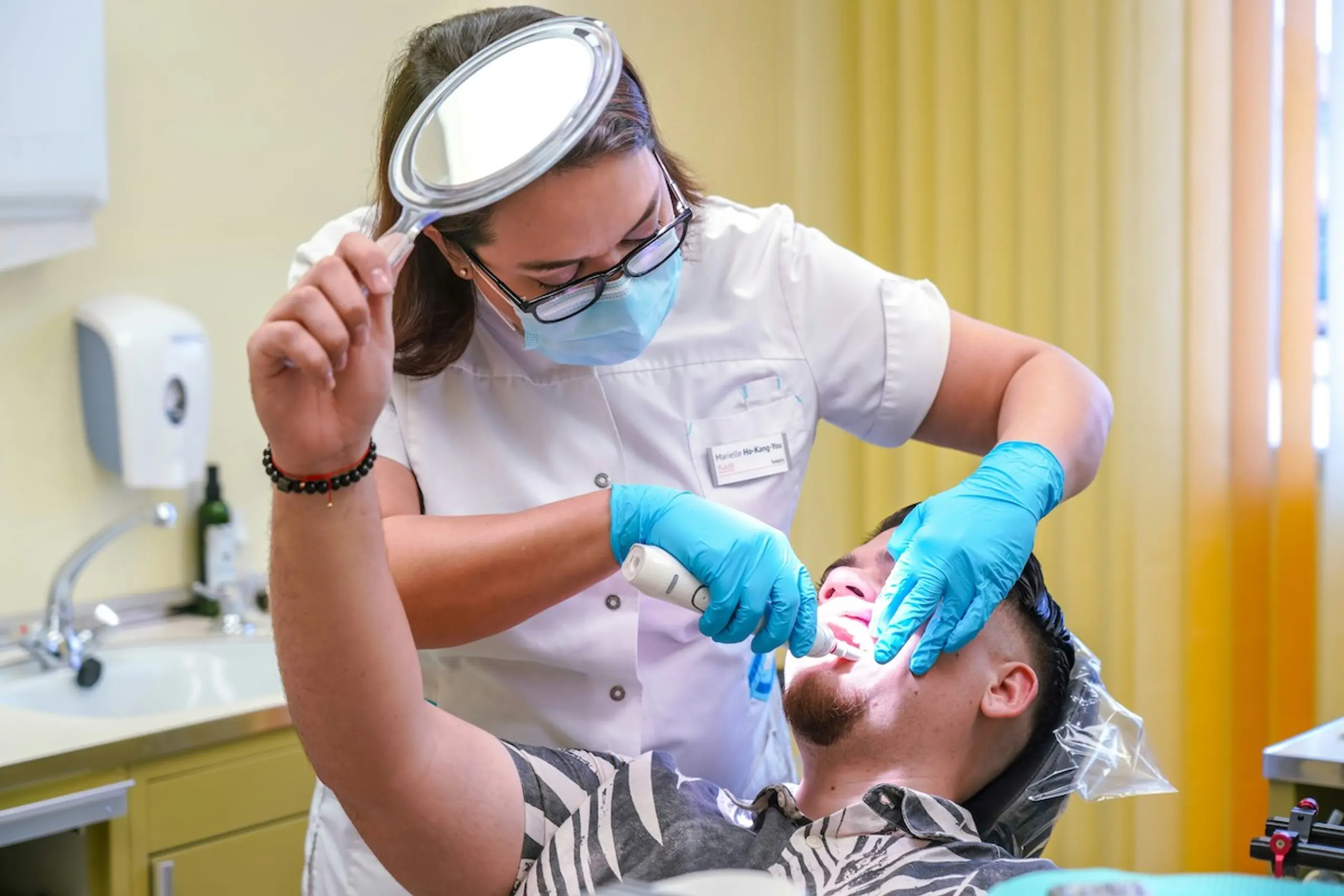 A dentist looking into a mans mouth