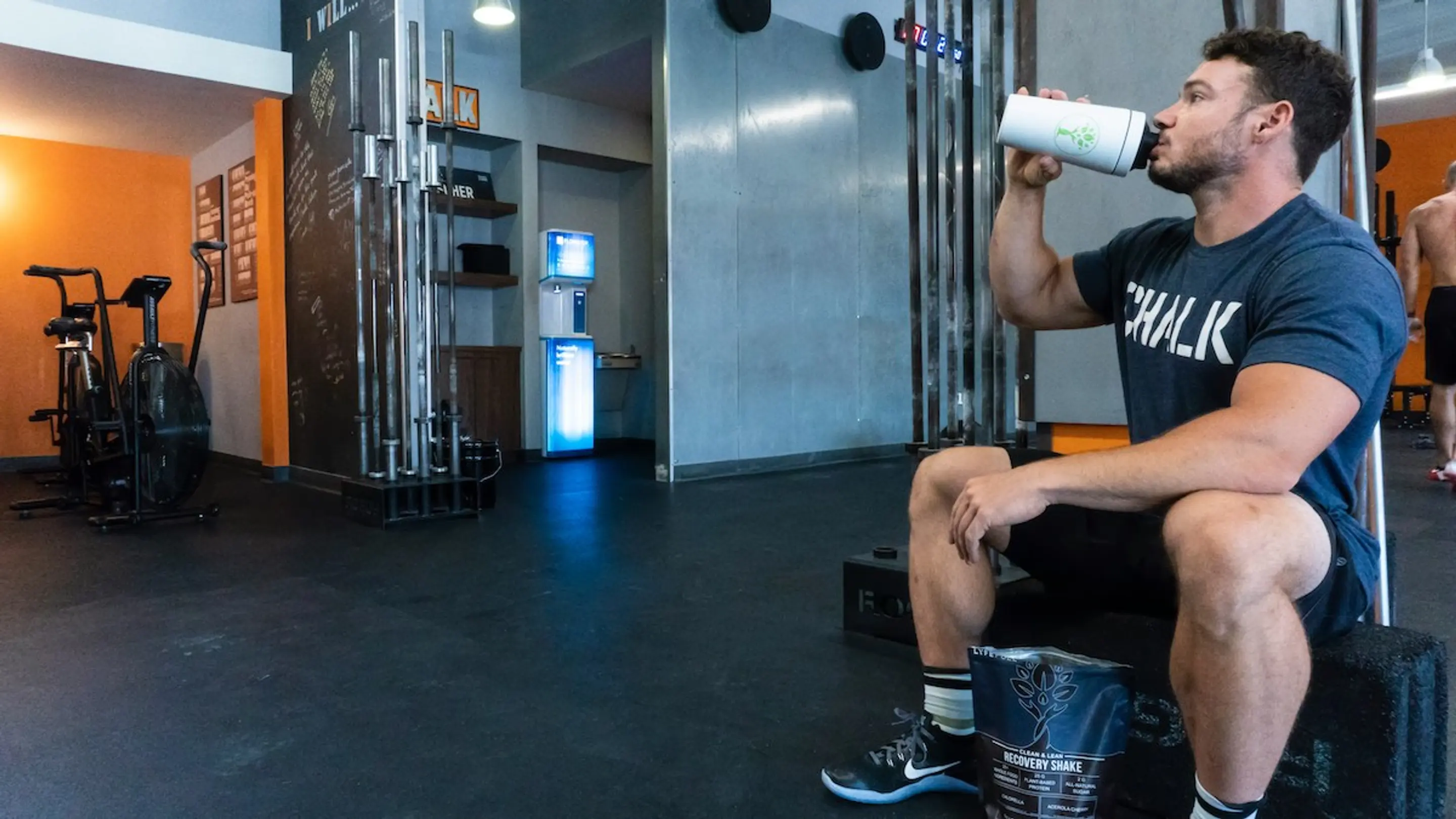 A man at the gym drinking a protein drink
