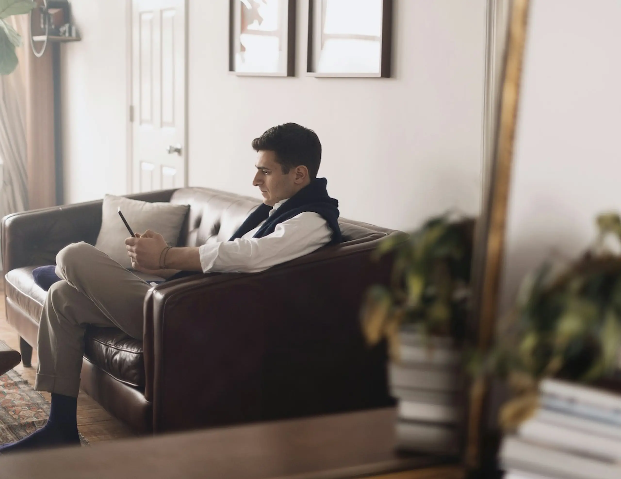 A man at home on the couch reading