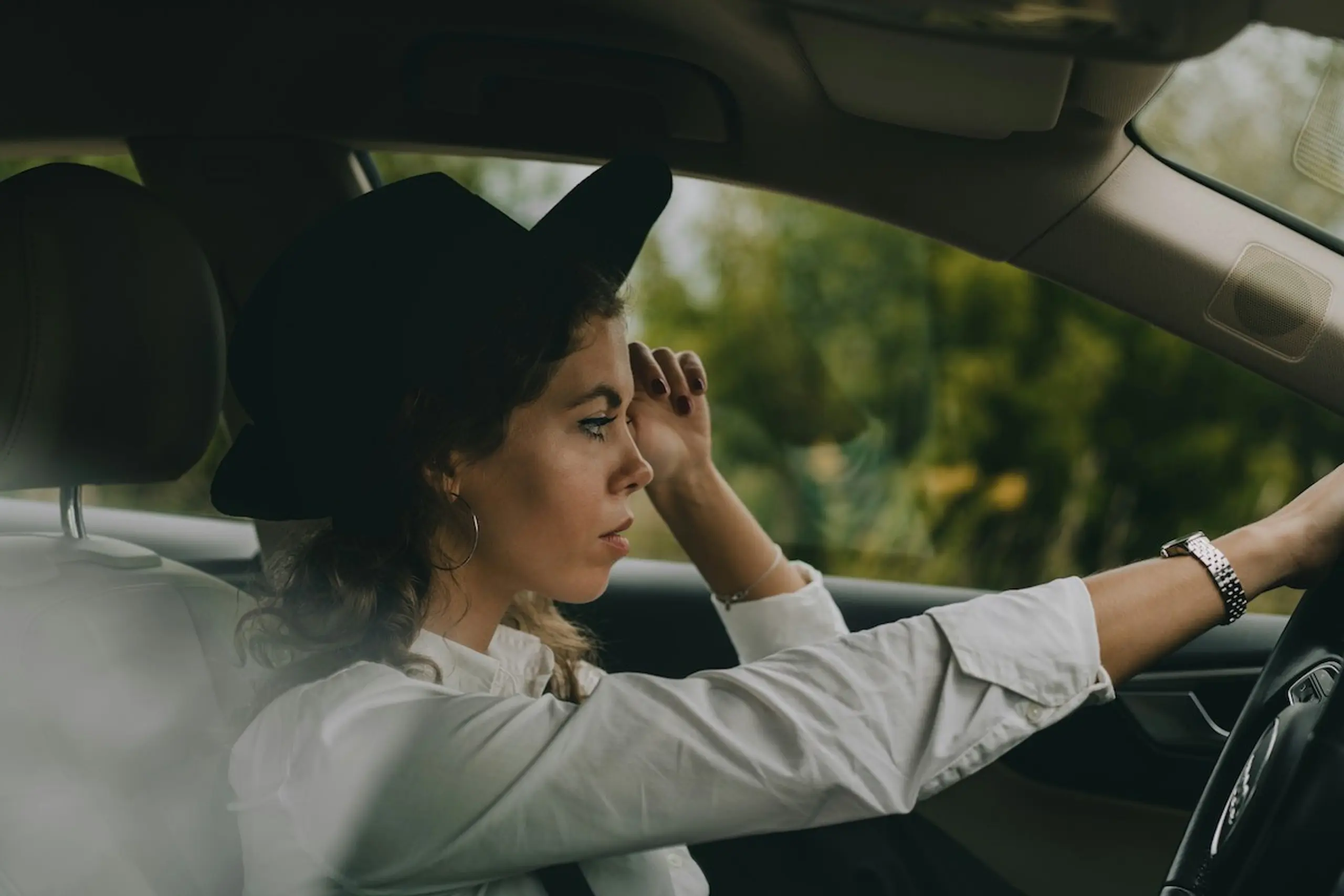 A concerned woman driving a car