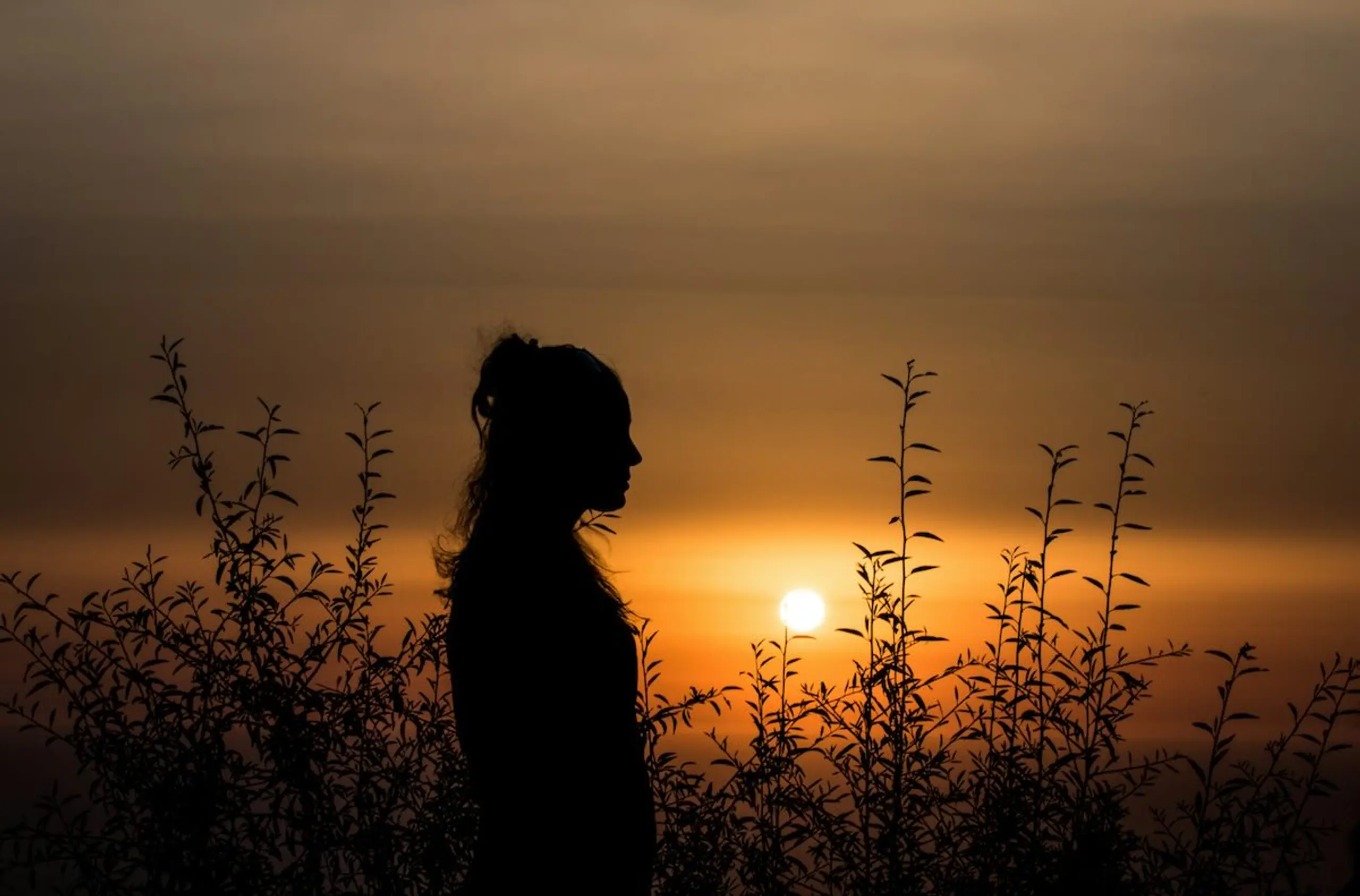 A woman looking to the side during sunset