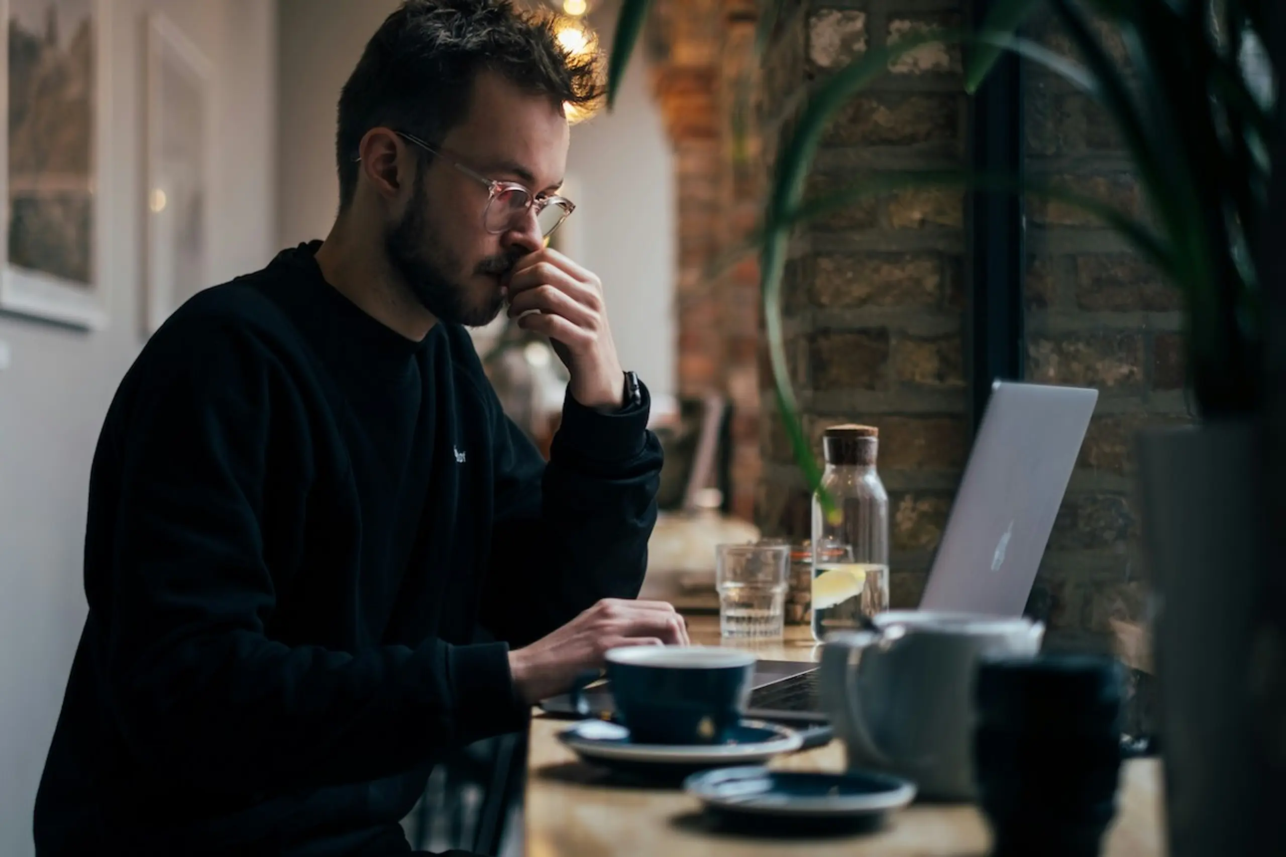 A man drinking tea while researching on the computer