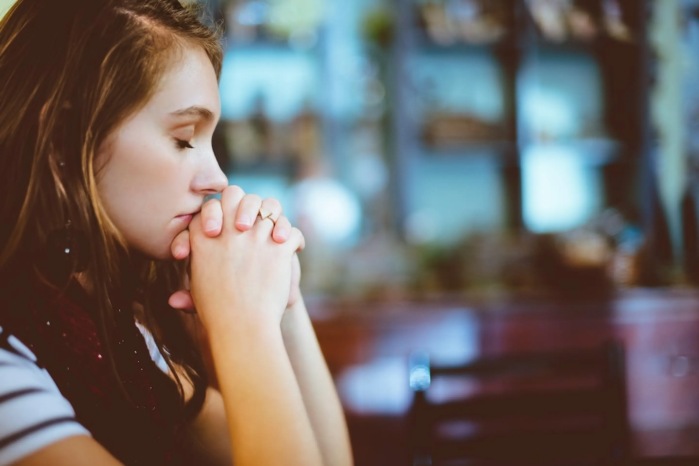 Woman thinking at a table with her eyes closed