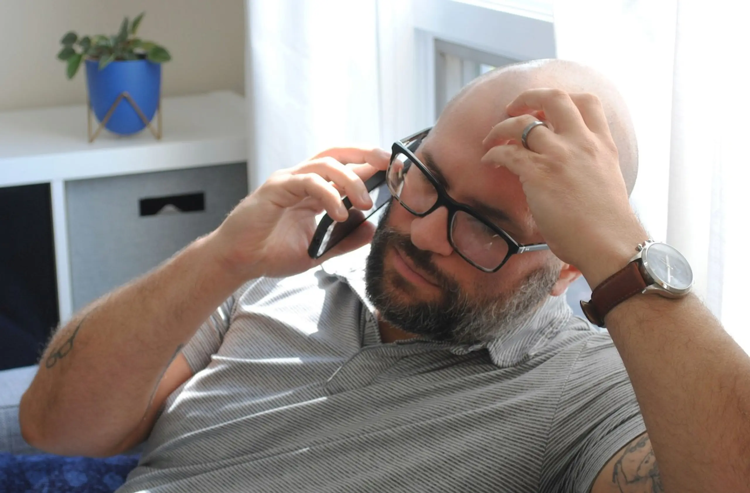 A man on a phone call on the couch