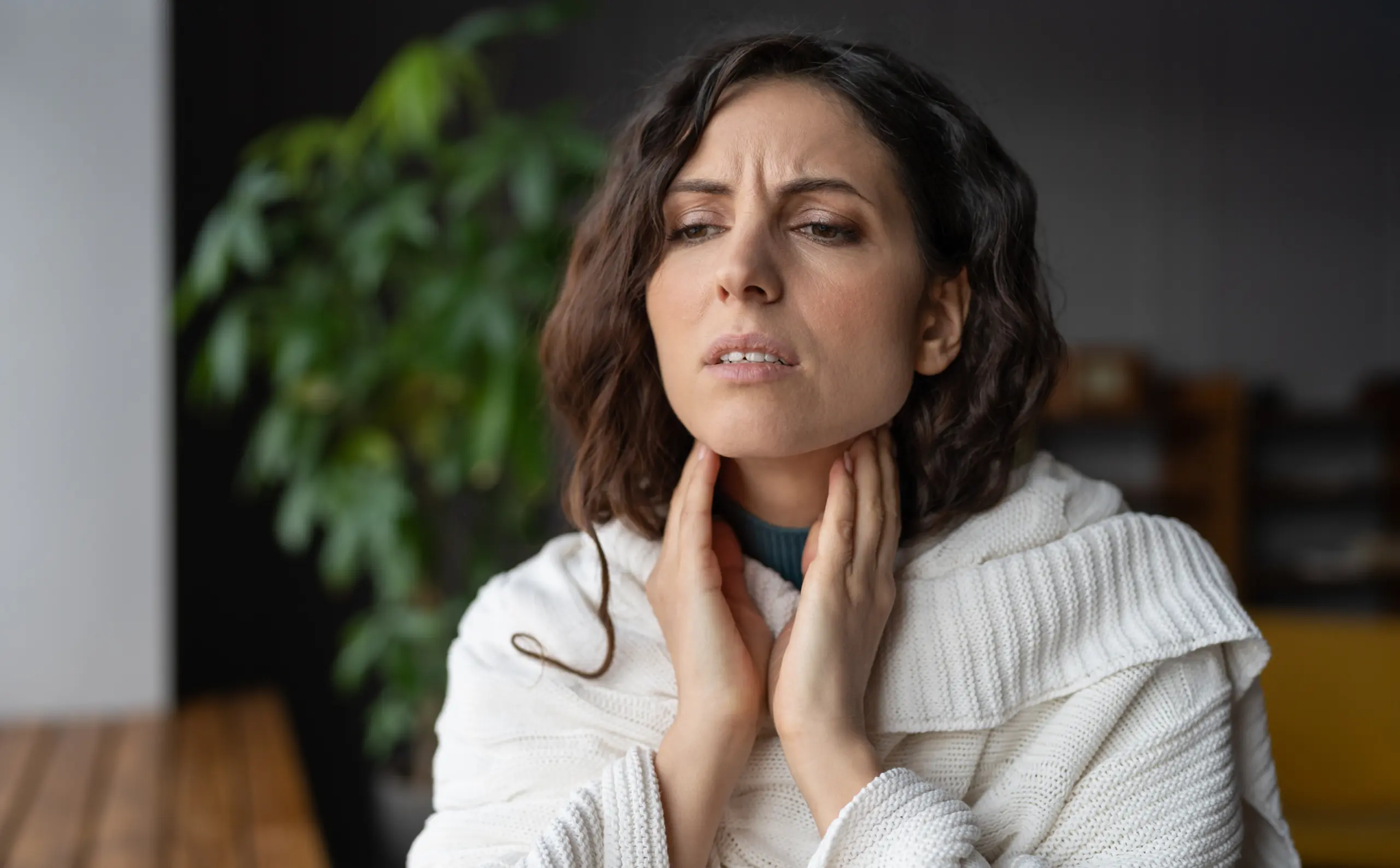 Woman touches sore throat