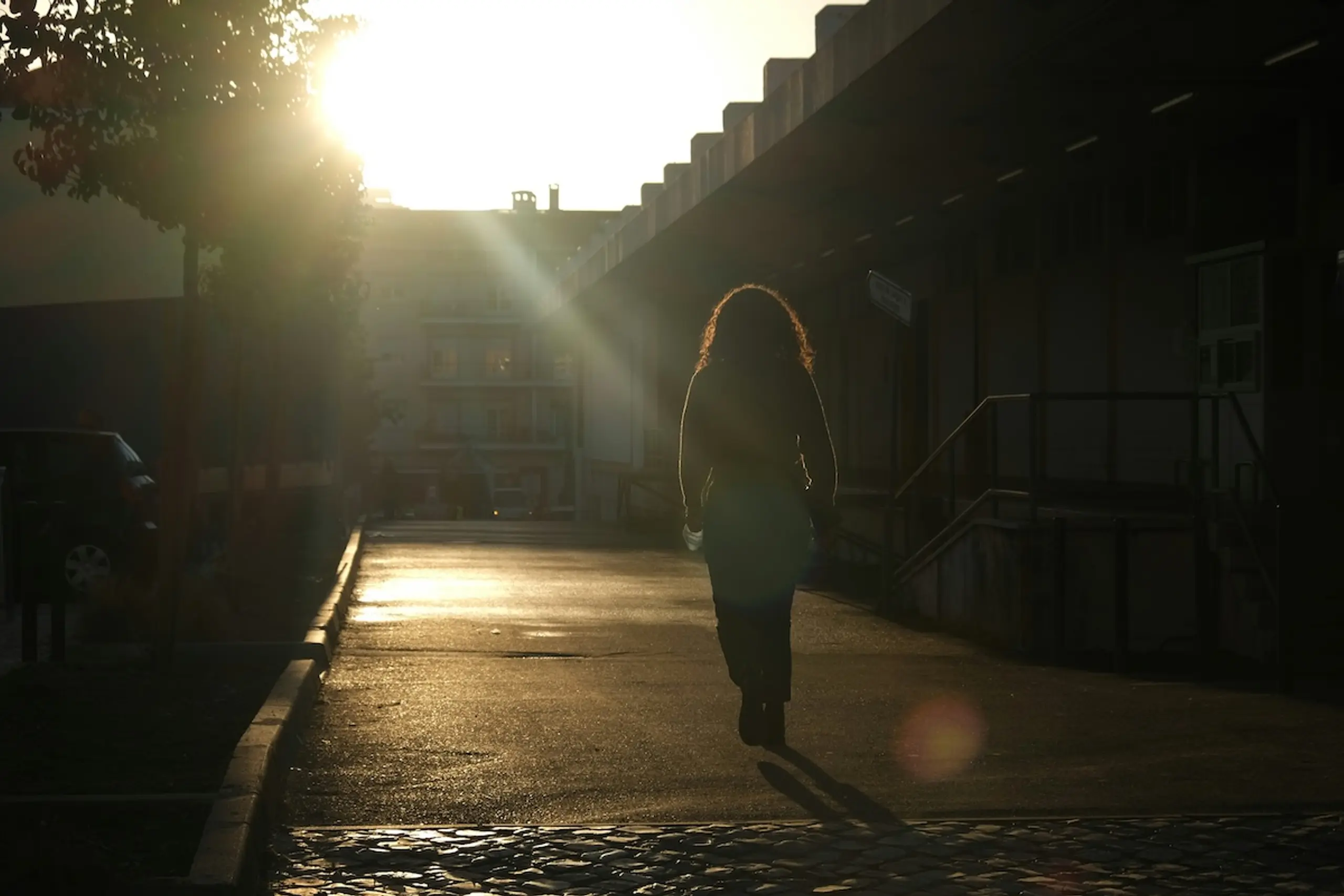 woman walking at sunset on pavement