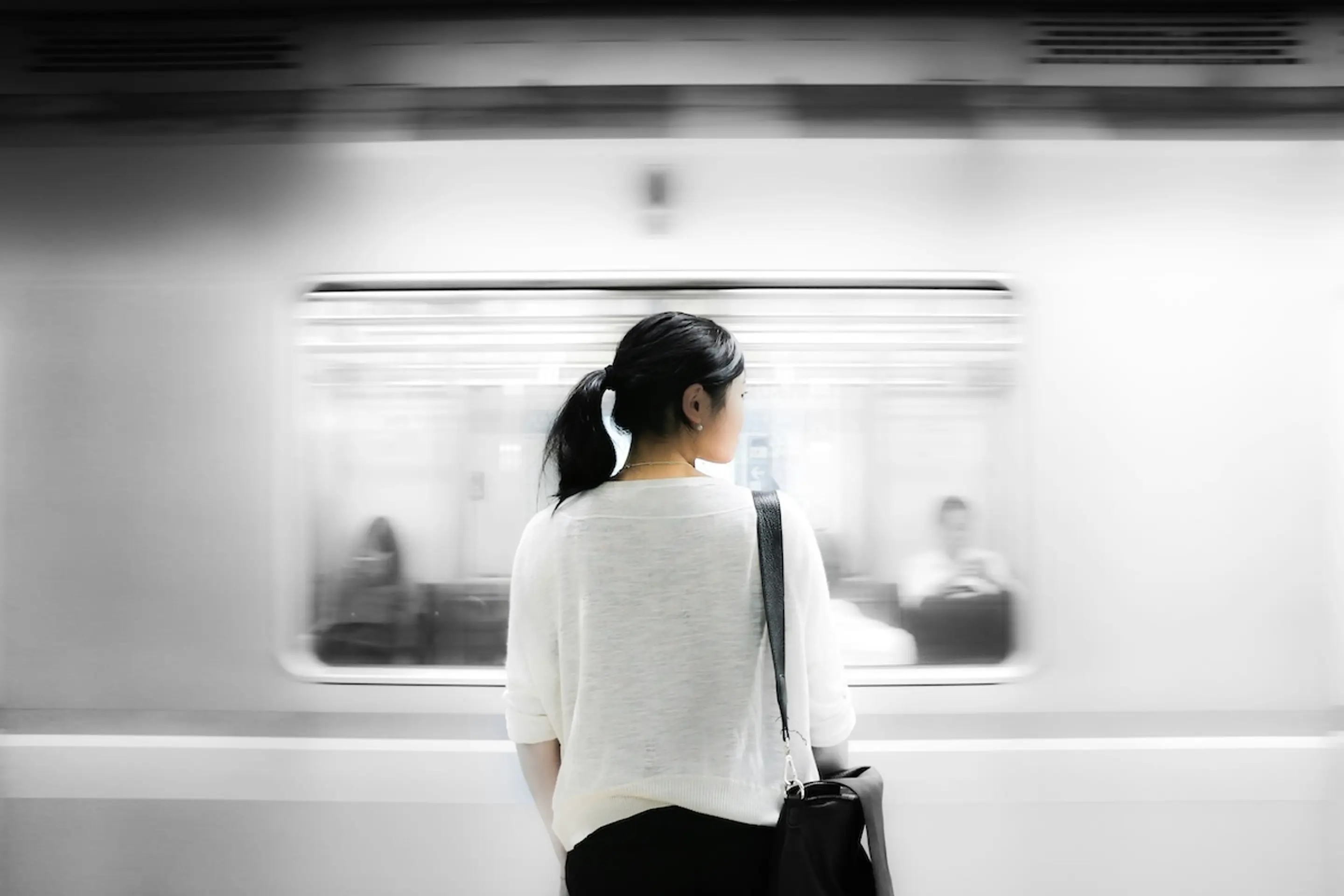 woman standing next to subway car looking to the right