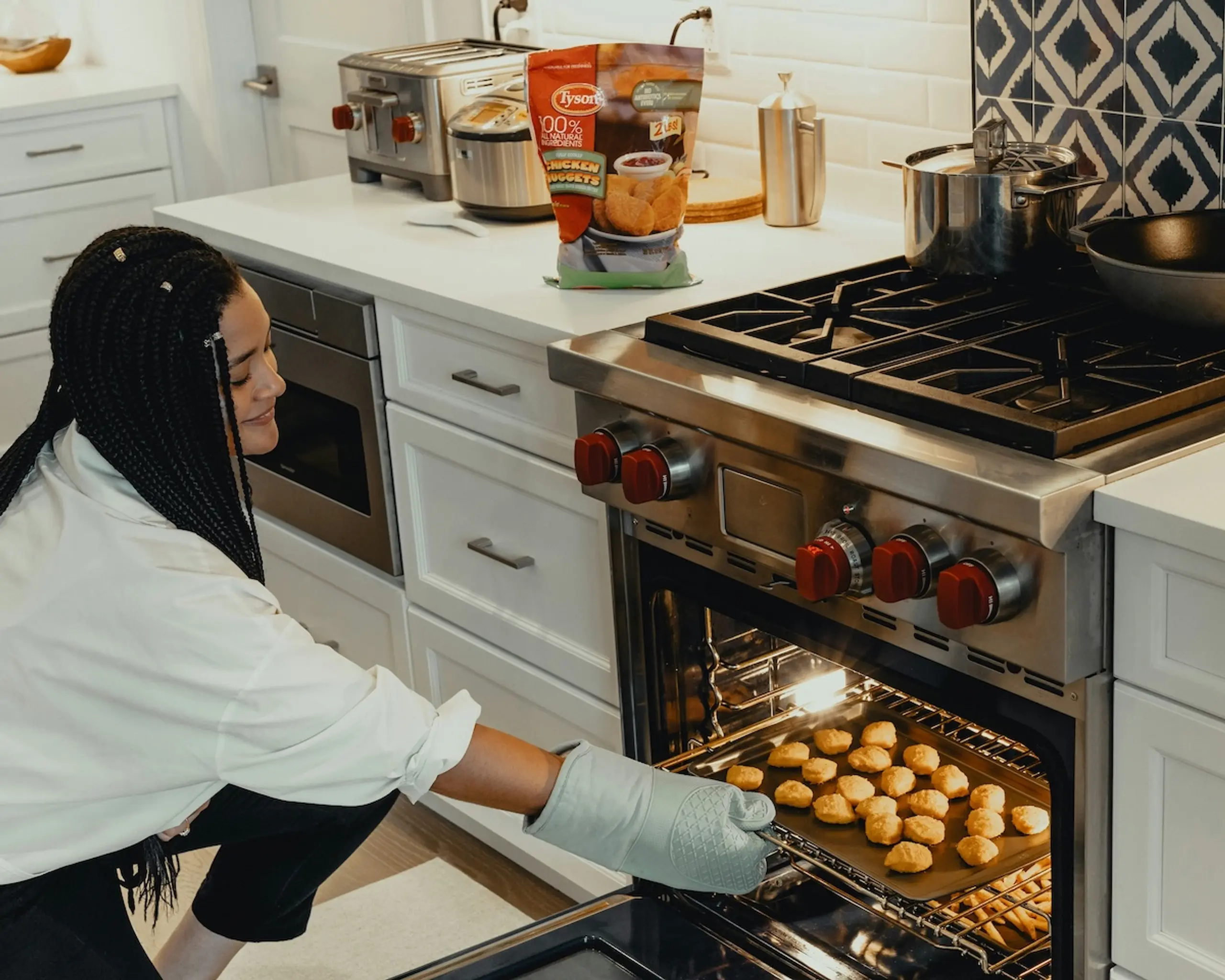 woman bending down taking a pan of food out of the oven