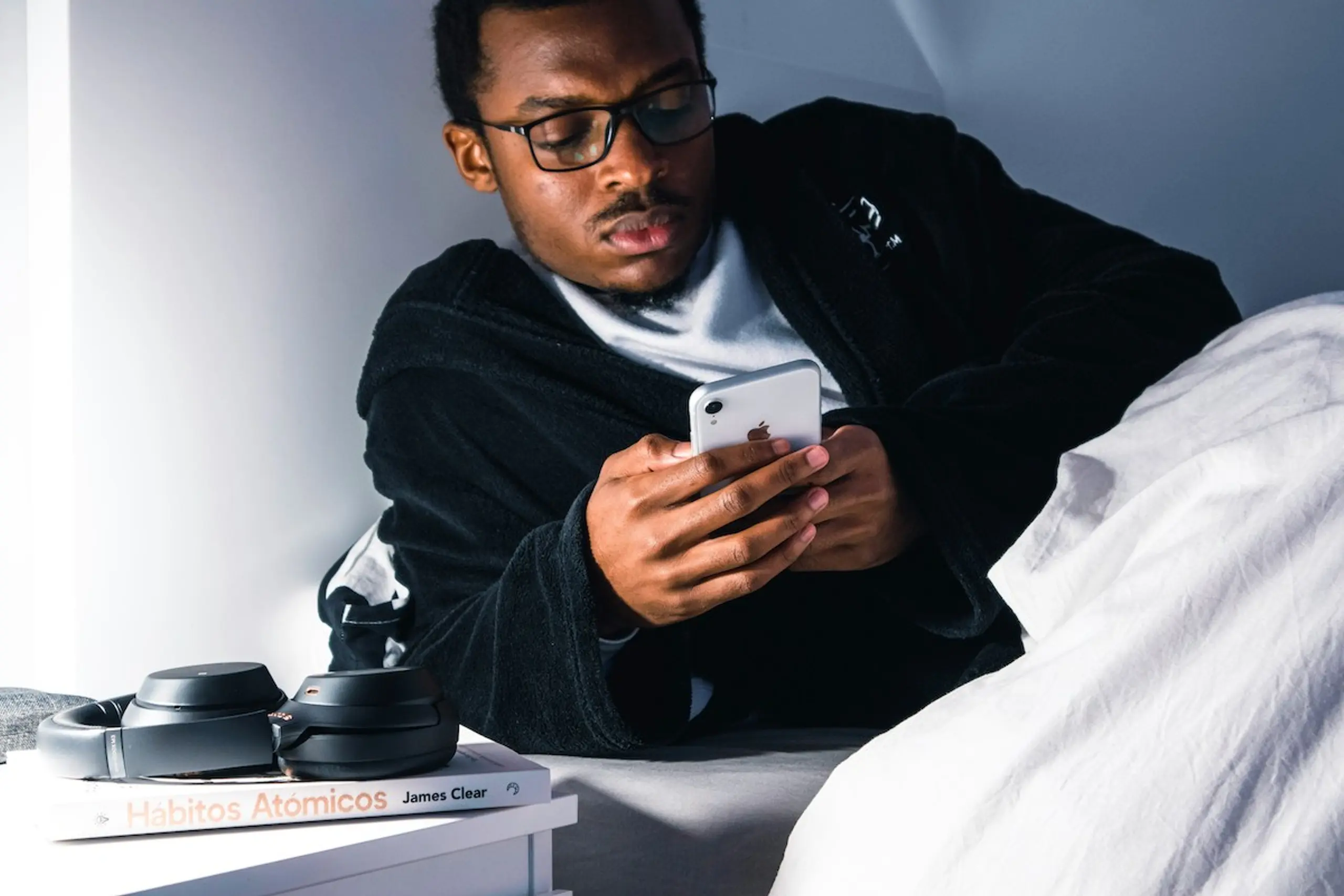A man researching on his phone in bed