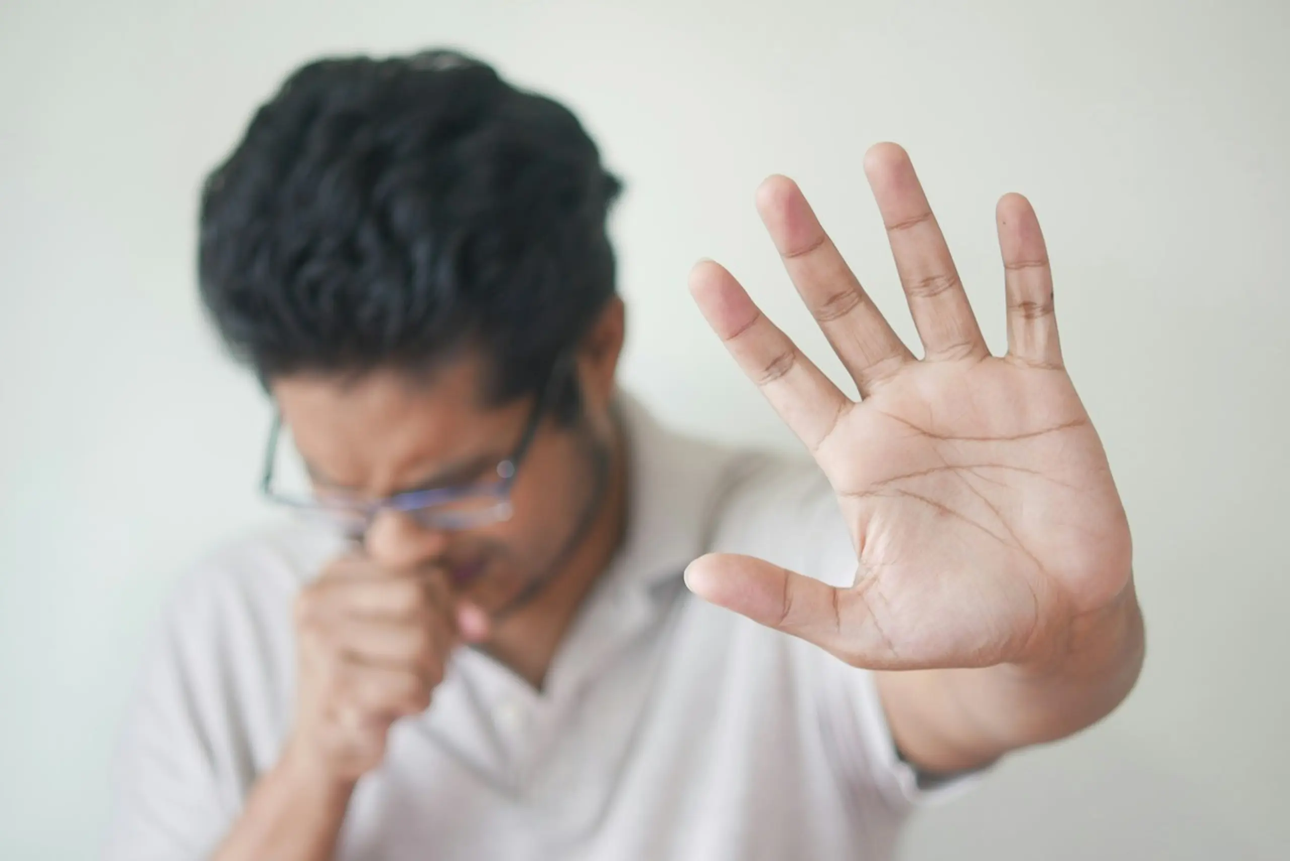 A man coughing into his fist