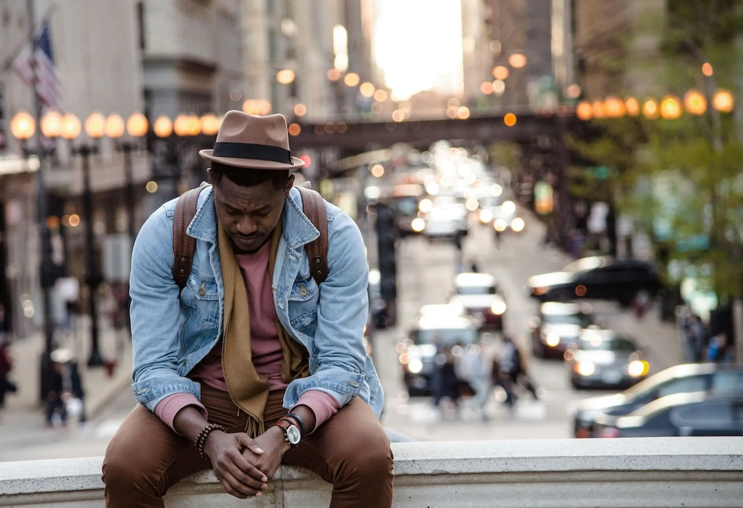 A man sitting on a bridge in the city