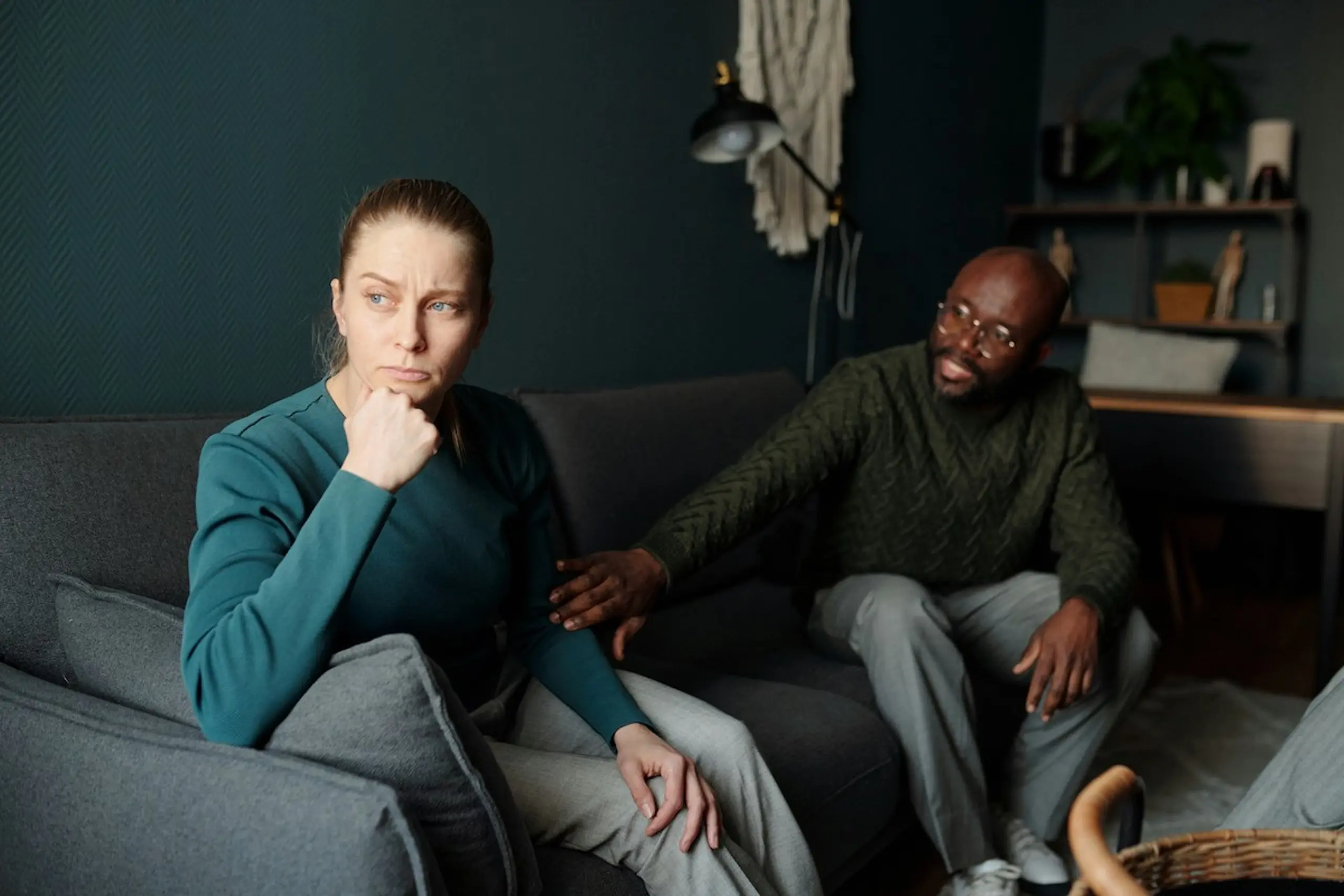 A man consoling a woman on a couch