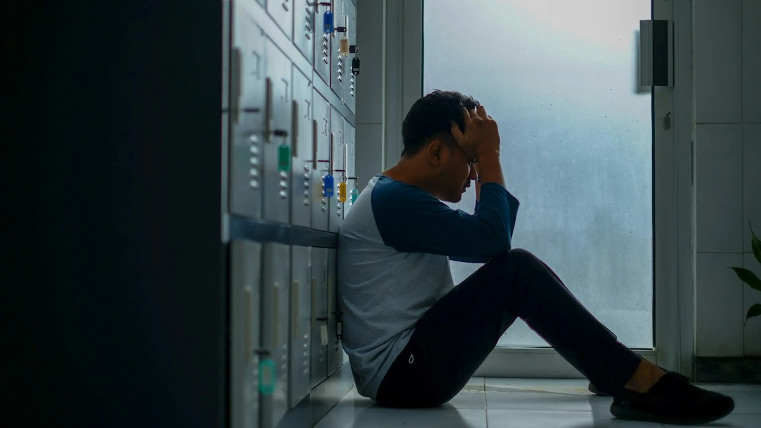 A man who is stressed out in a locker room