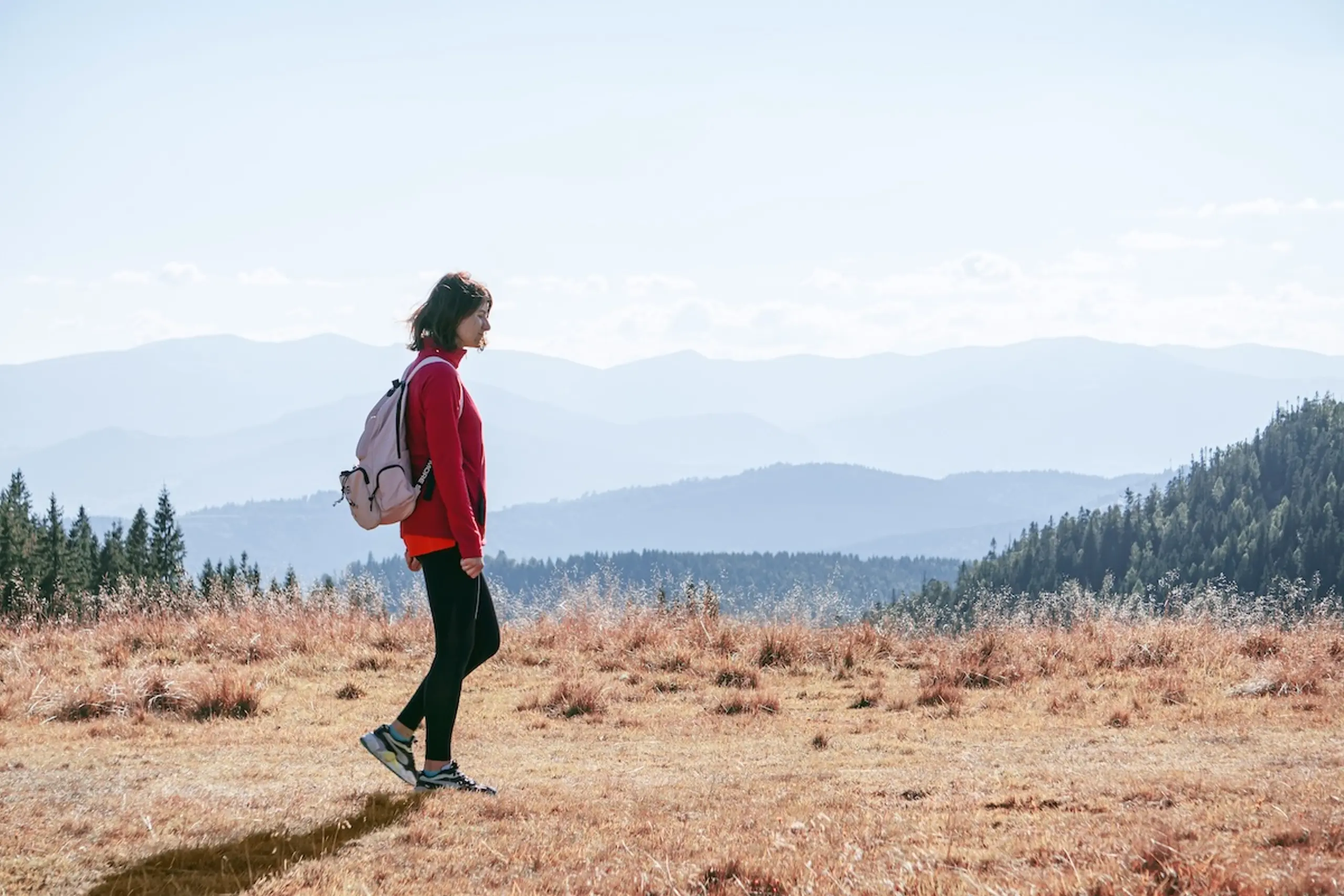 woman hiking on trail with backpack