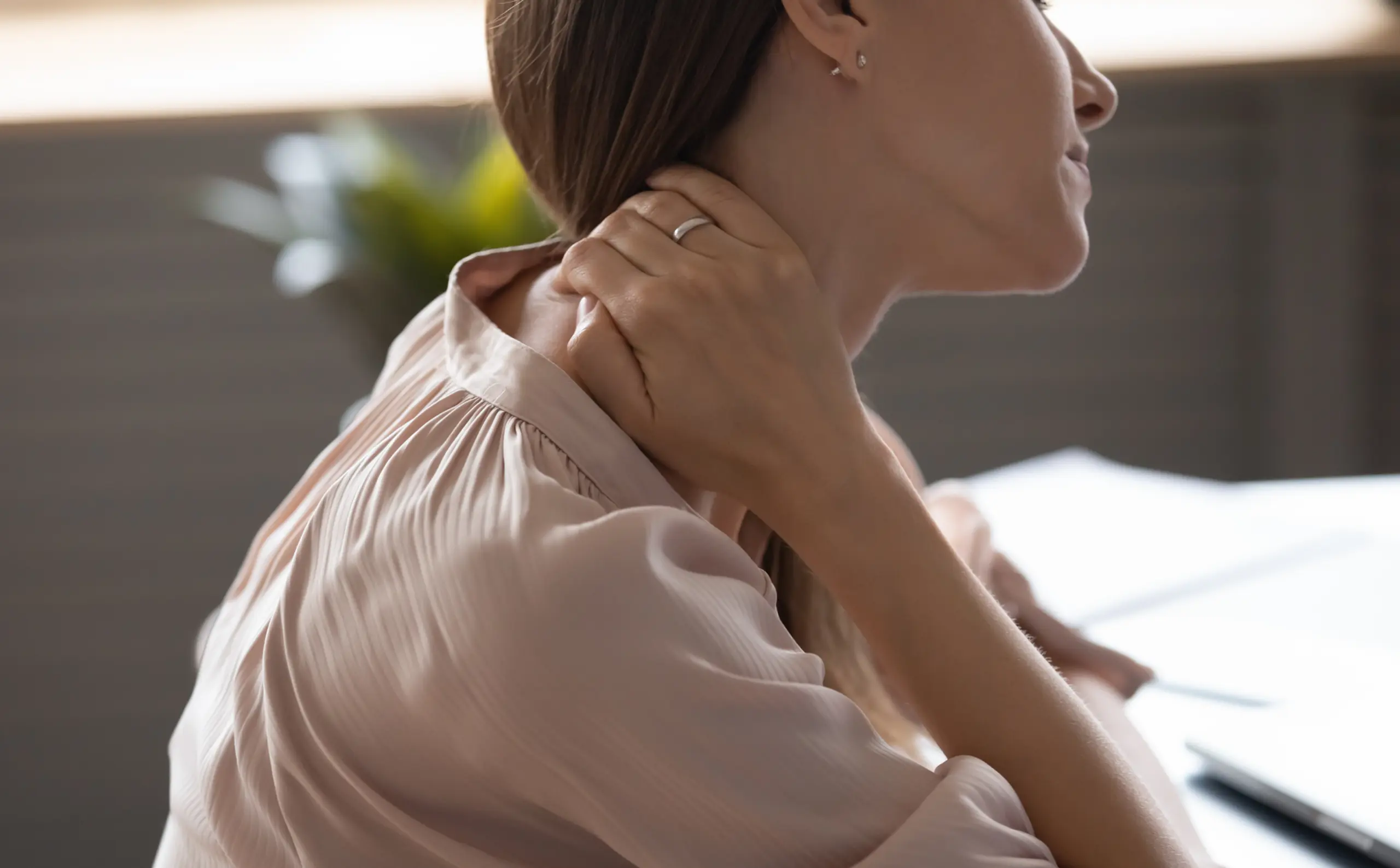Woman holds side of neck 