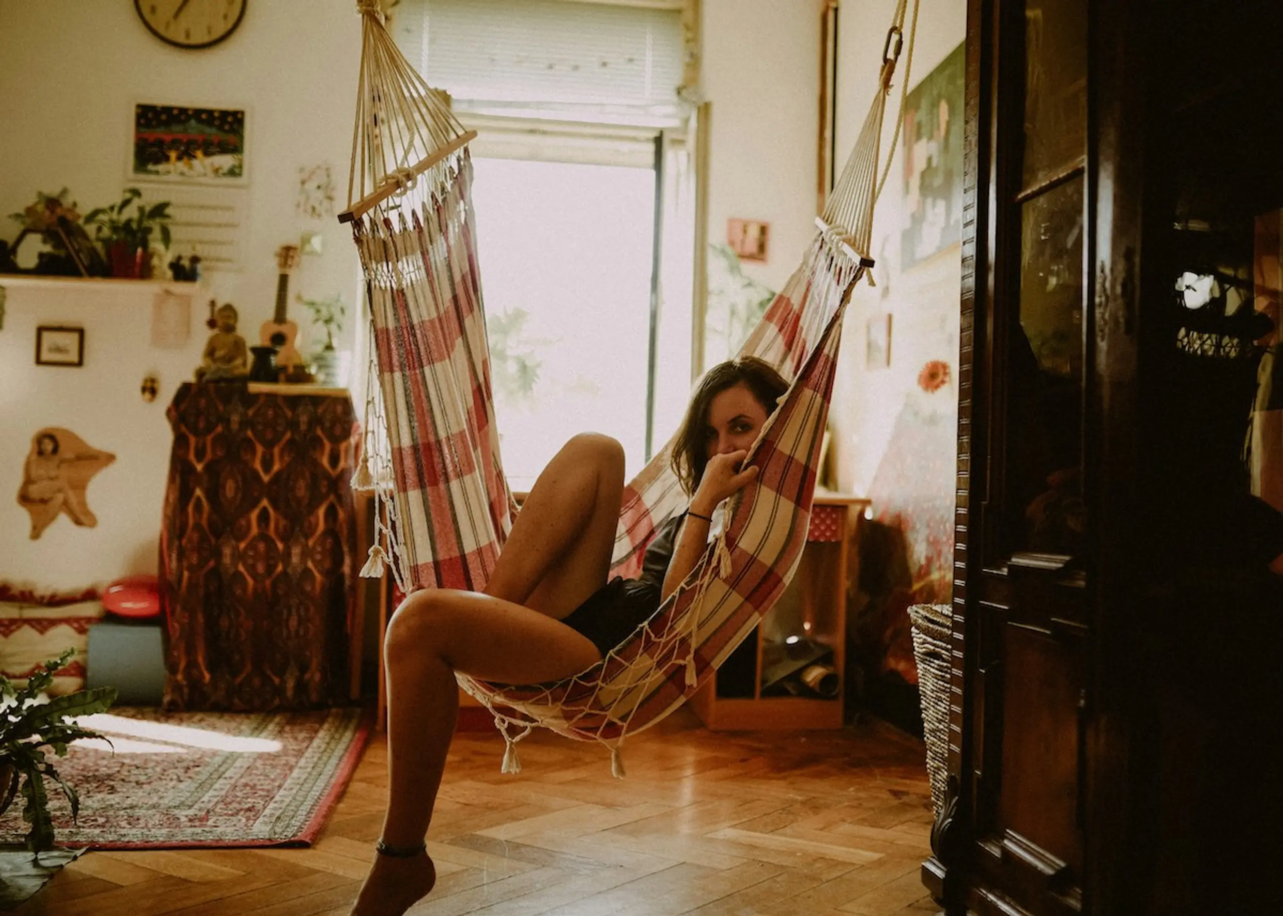A woman sitting in a hammock at home