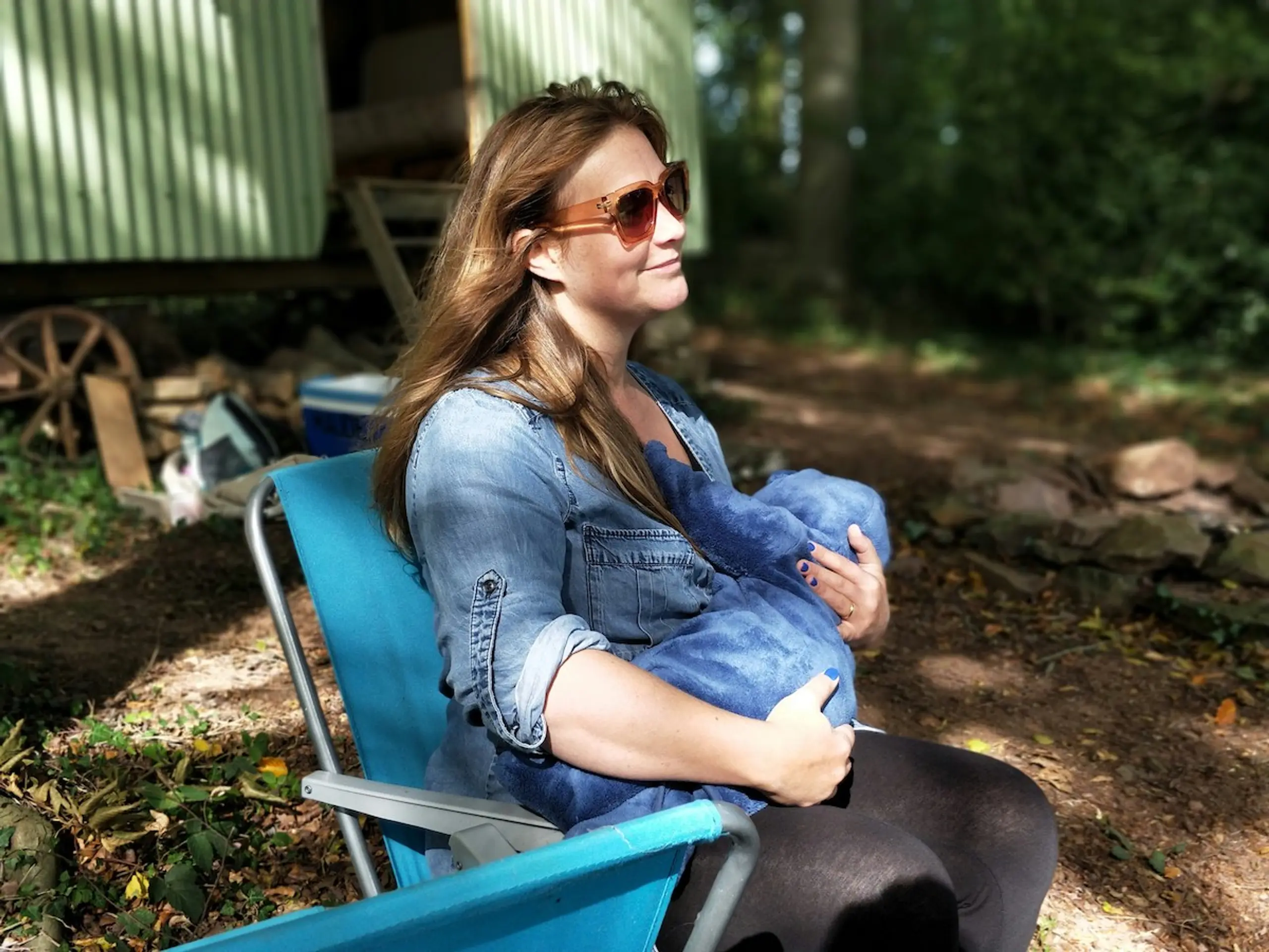A woman sitting outside with her baby
