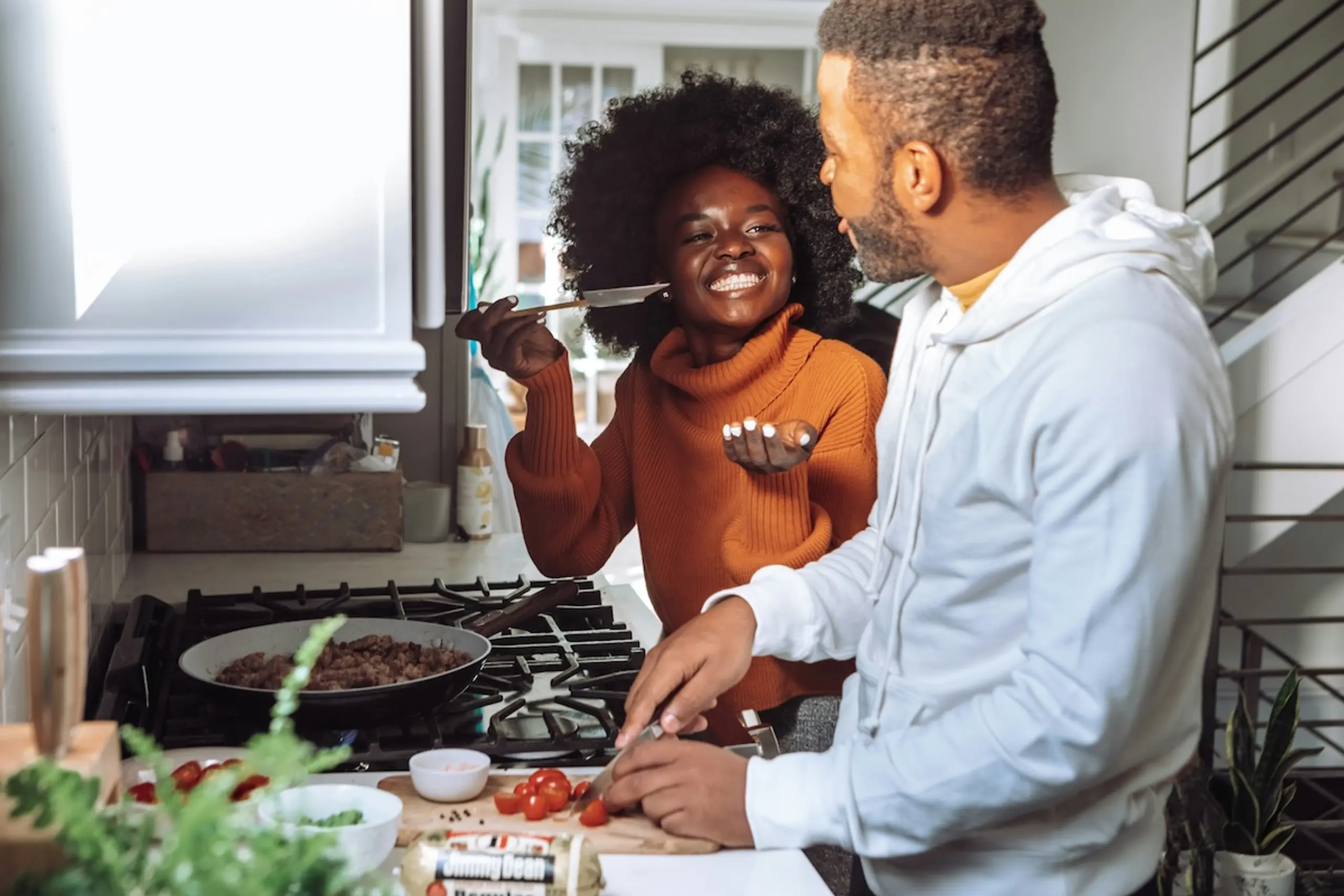 A couple cooking meal in a kitchen
