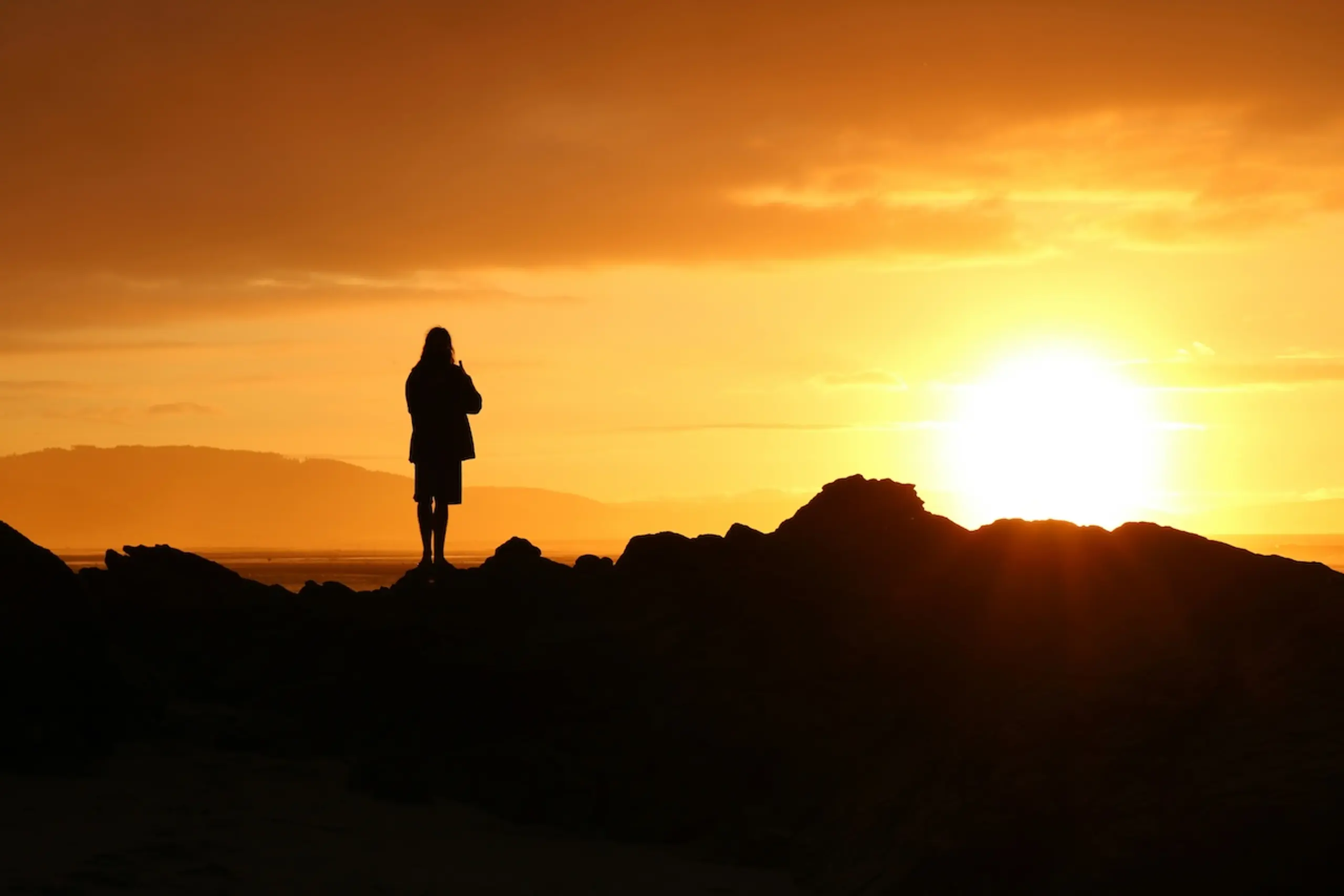 person standing on mountain watching sunrise