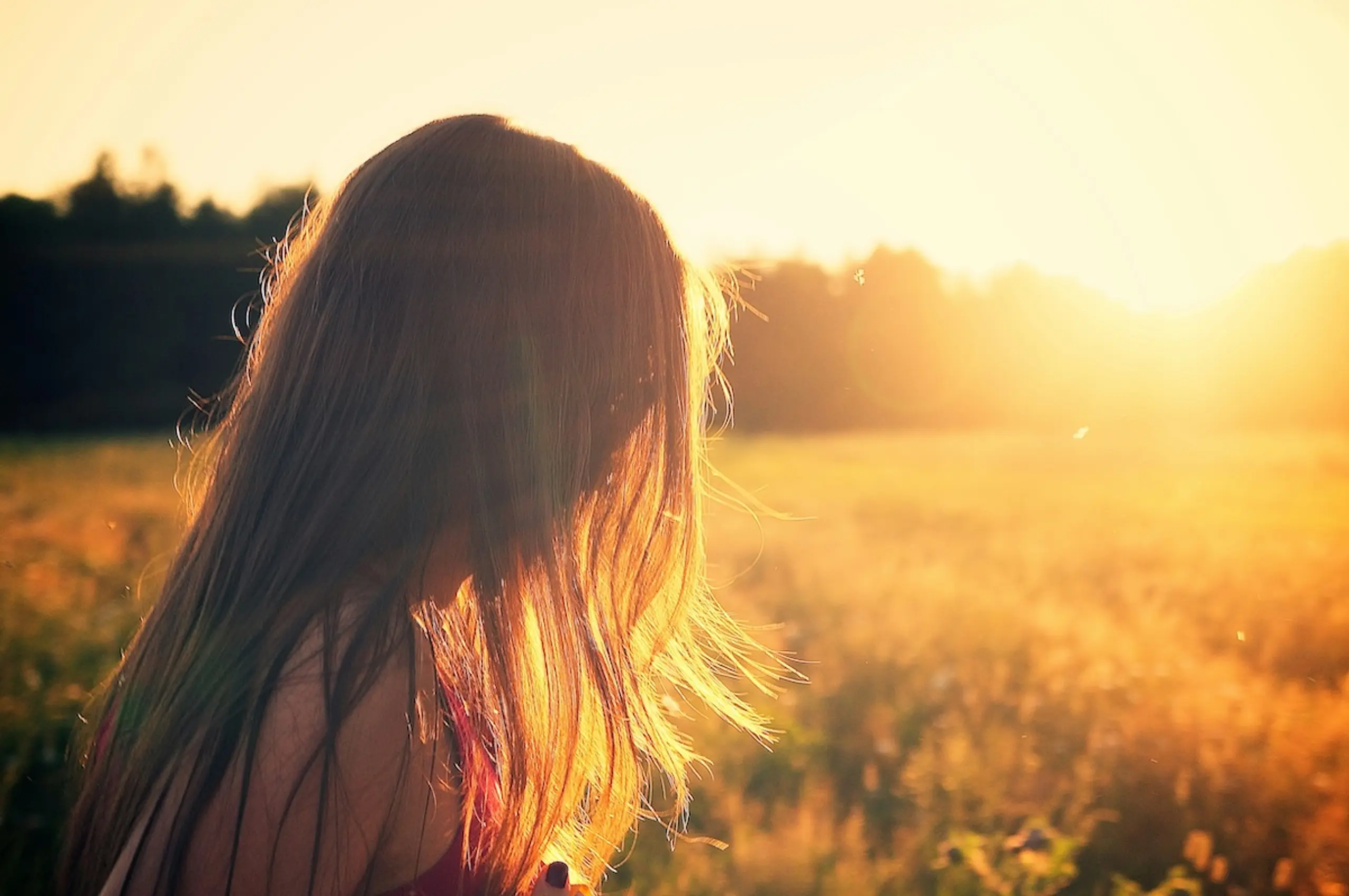 woman in grassy meadow with sunlight