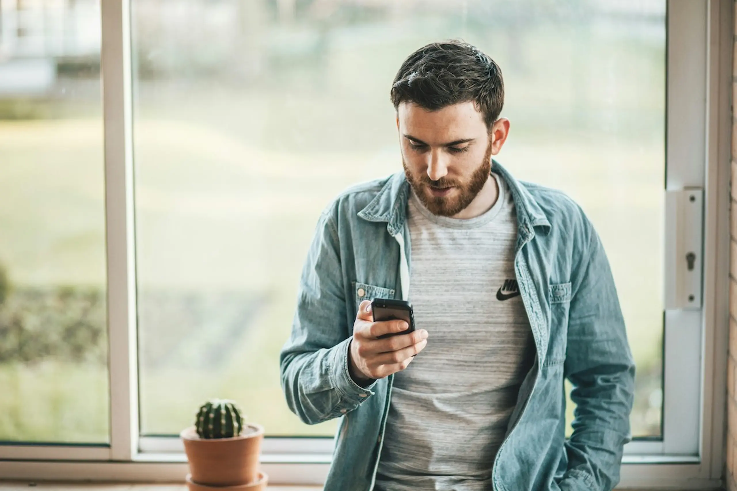 A man on his phone at home by the window