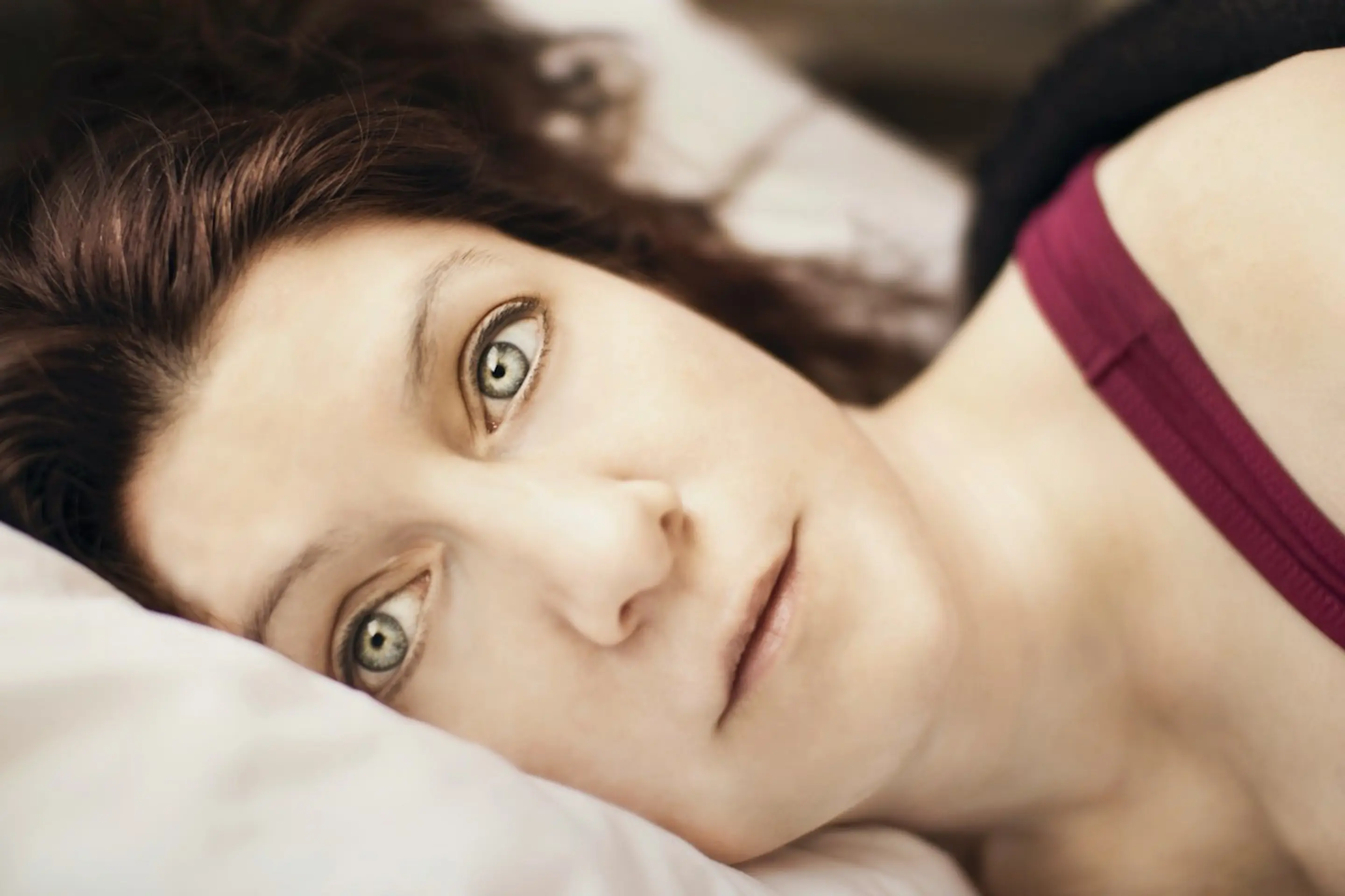 A woman lying awake in bed in the morning