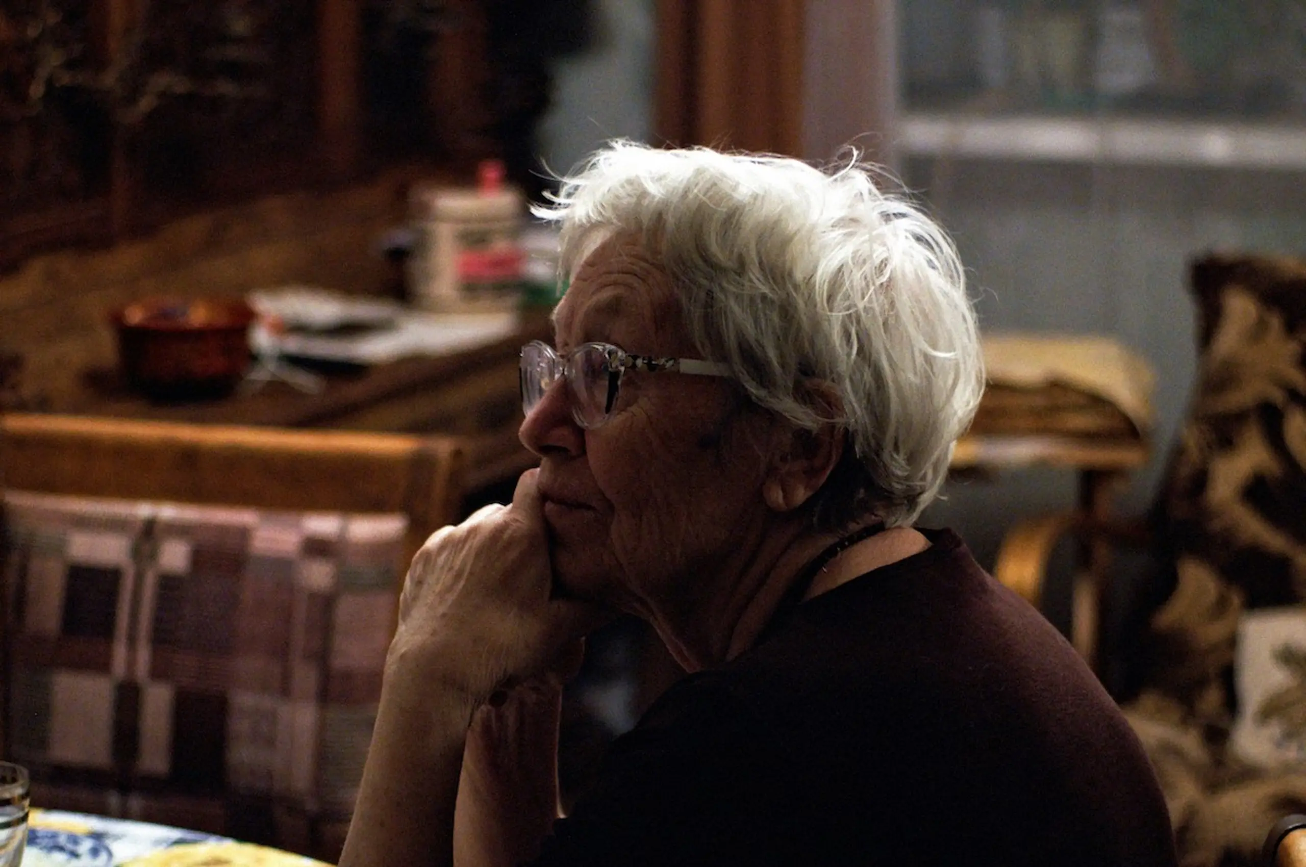 An older woman who is sitting and thinking