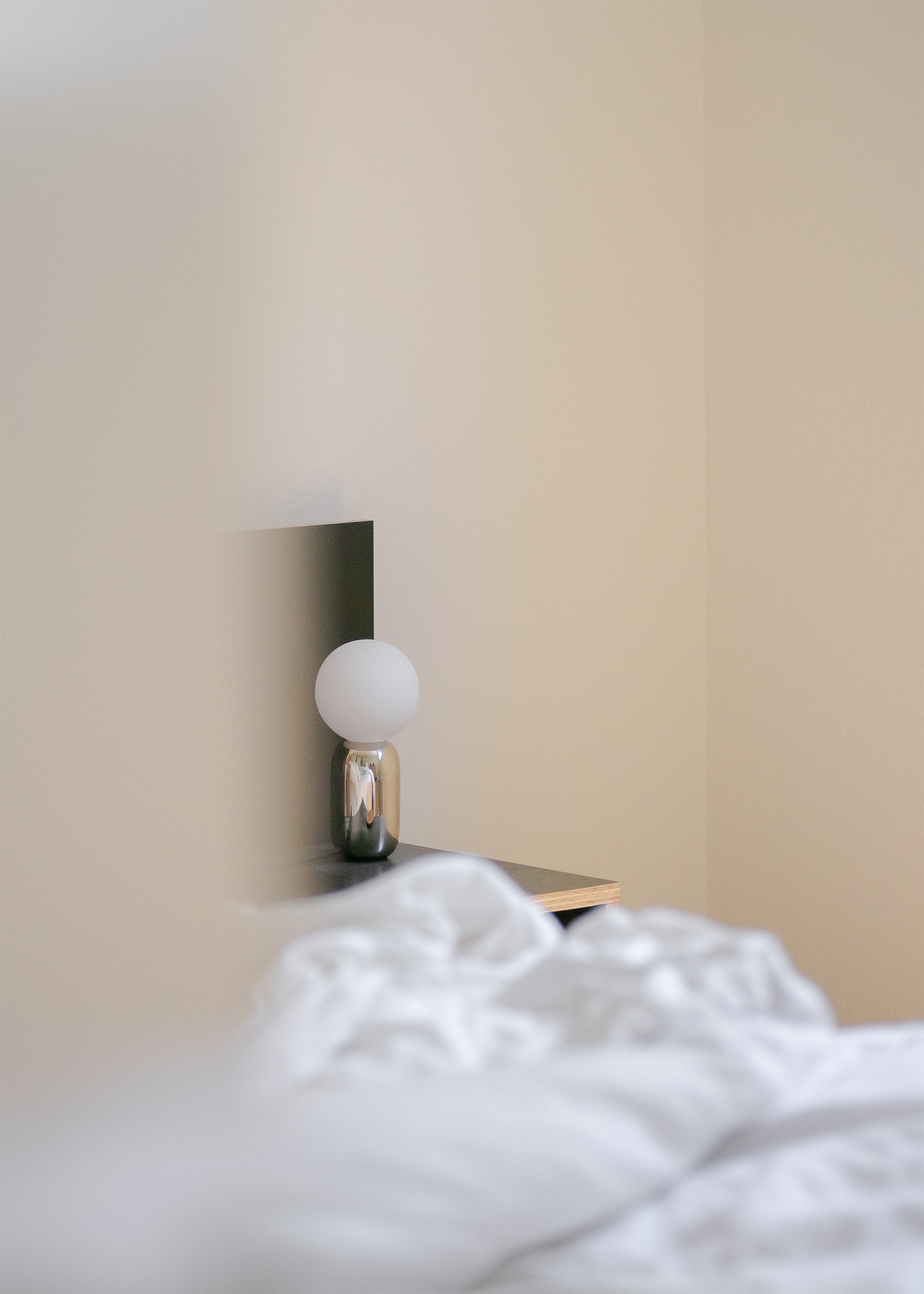 Bubble lamp in silver on side table in bedroom
