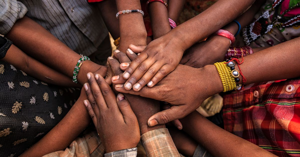 A group of people placing their hands atop one another's