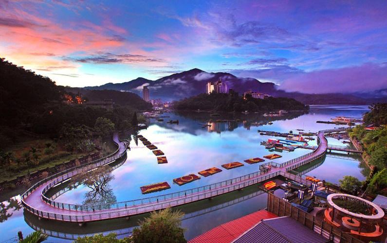 Cruise across the scenic Sun Moon Lake surrounded by mountain views.