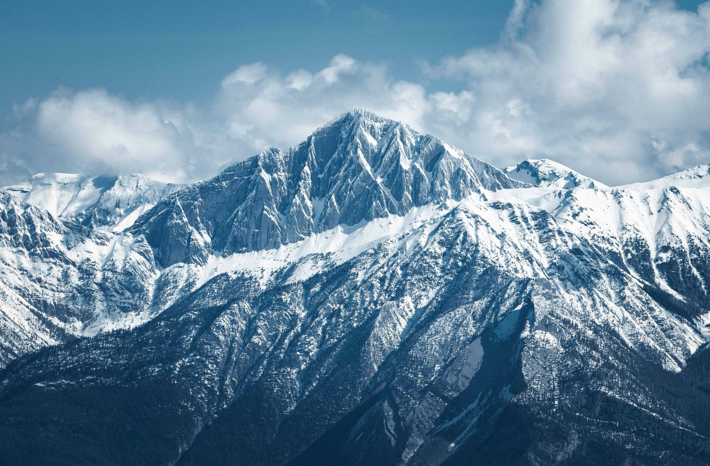 Schneebedeckter Berggipfel unter blauem Himmel