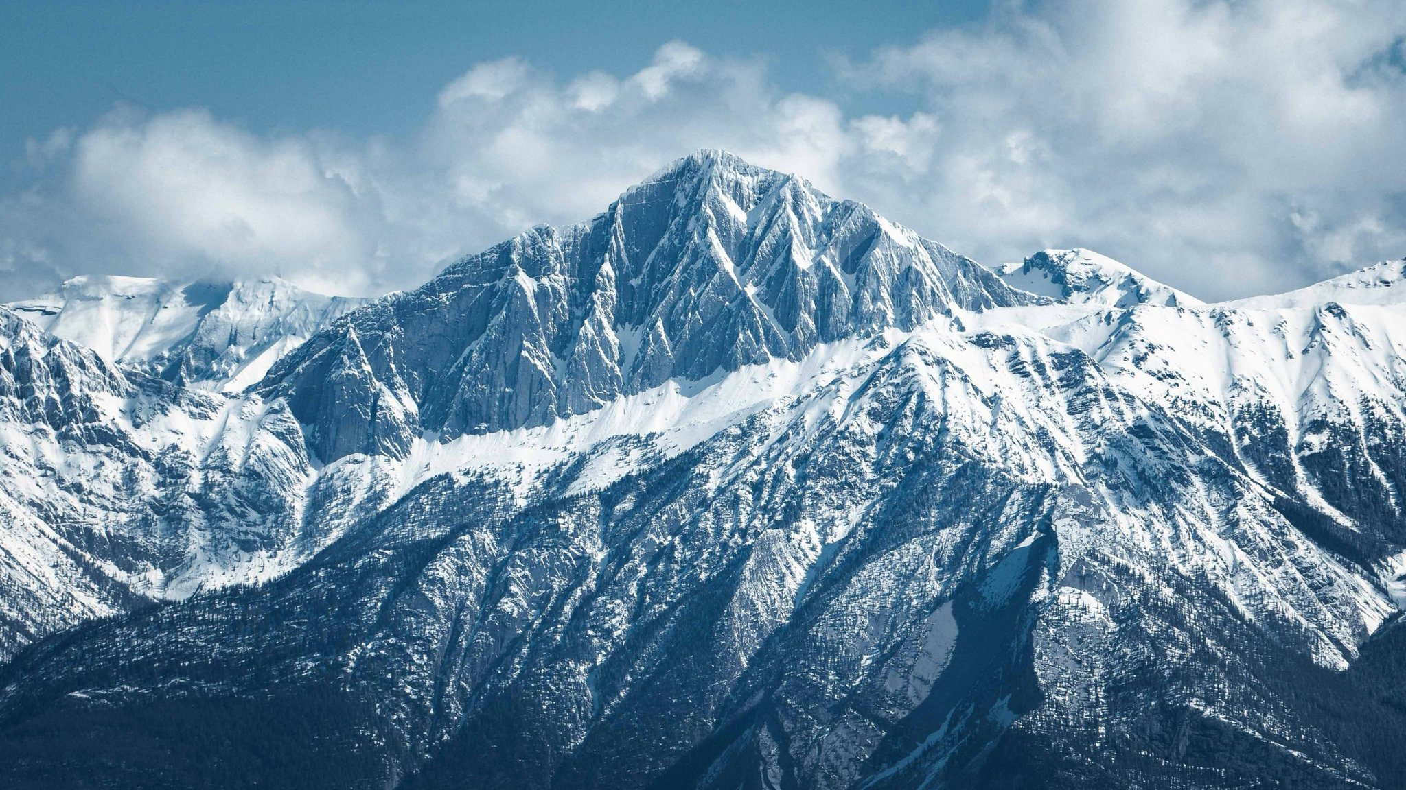 Schneebedeckter Berggipfel unter blauem Himmel