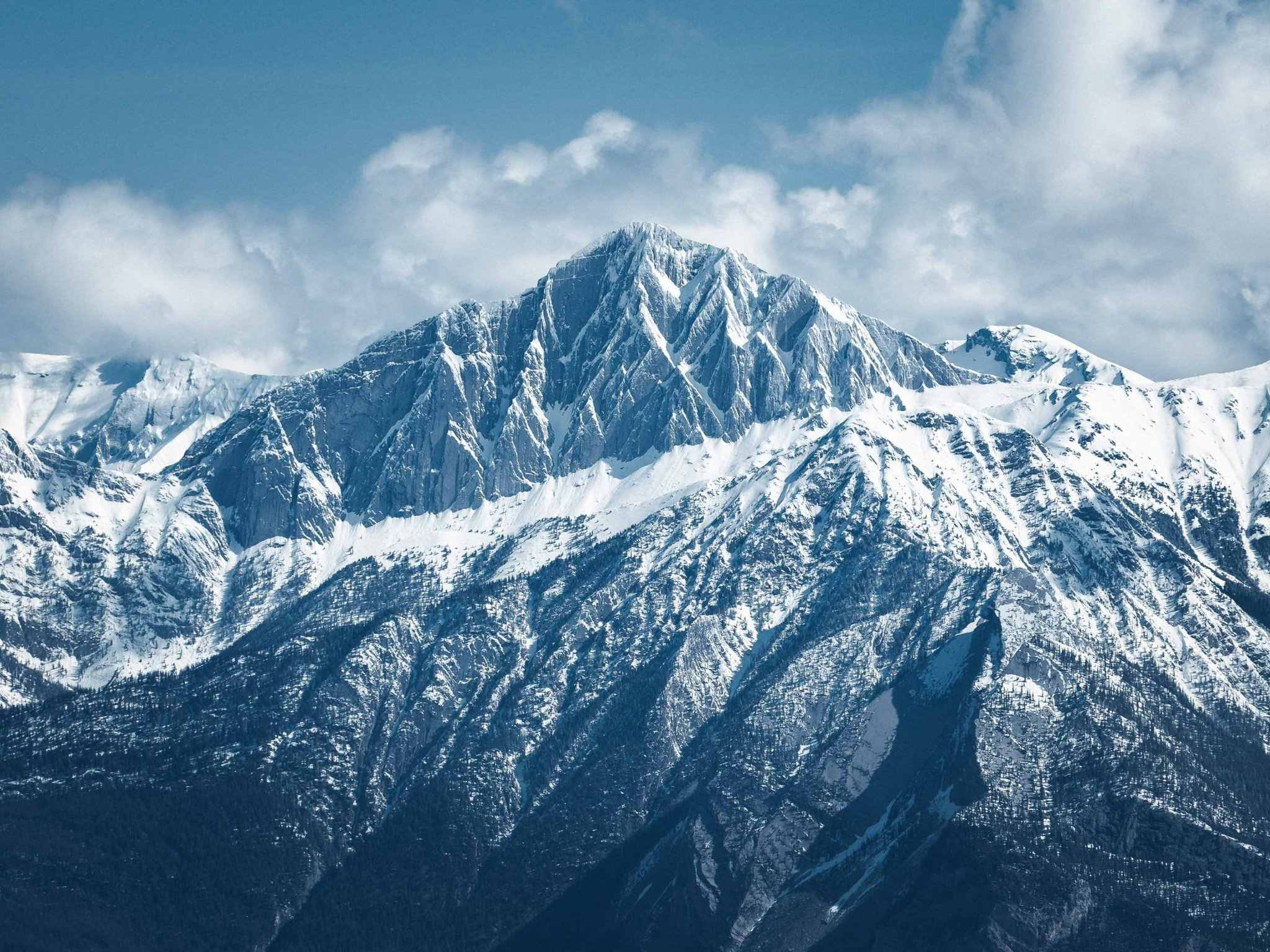 Schneebedeckter Berggipfel unter blauem Himmel