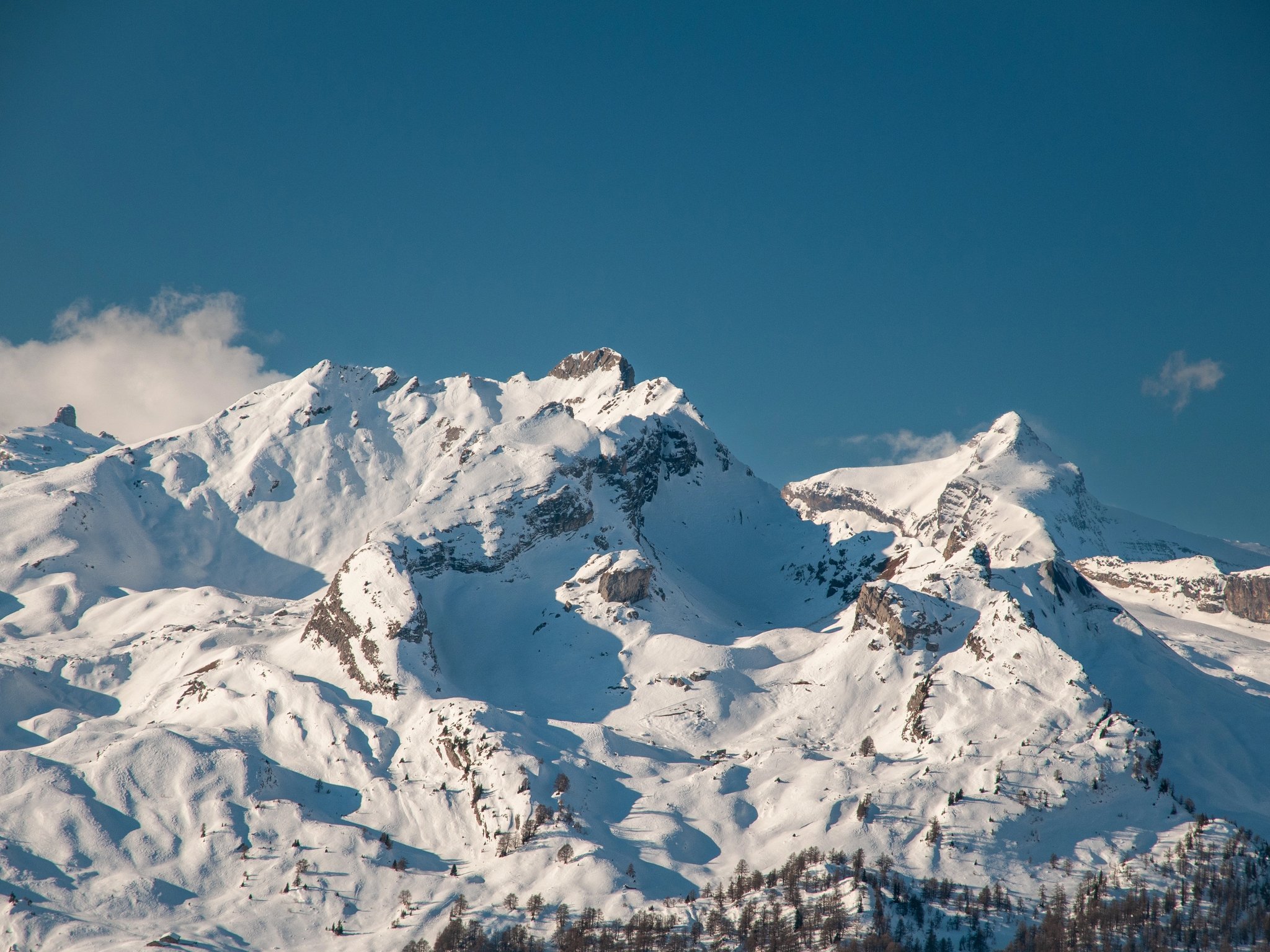 Snow-covered Alpine peaks beneath a clear sky