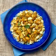 A plate with butter chicken and rice