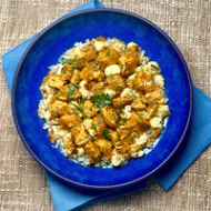 A plate with butter chicken and rice