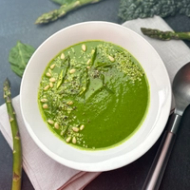 A bowl of green soup in a white dish