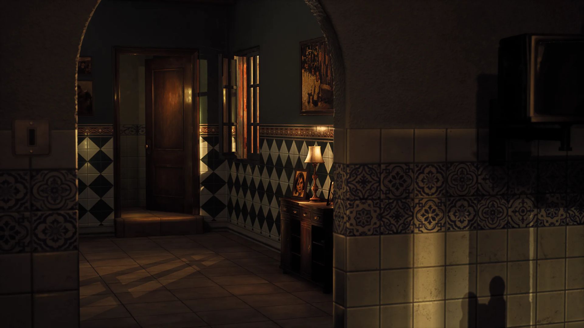 Dark corridor with patterned wall tiles, an arched doorway and light spilling from a side room