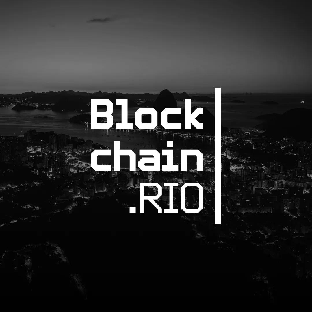 The Blockchain.RIO wordmark in white over a black-and-white night photograph of the Rio de Janeiro coastline