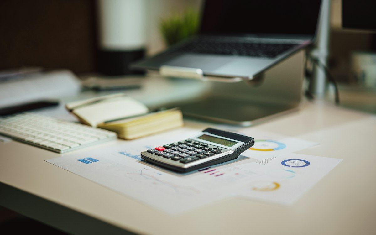 A calculator beside a laptop